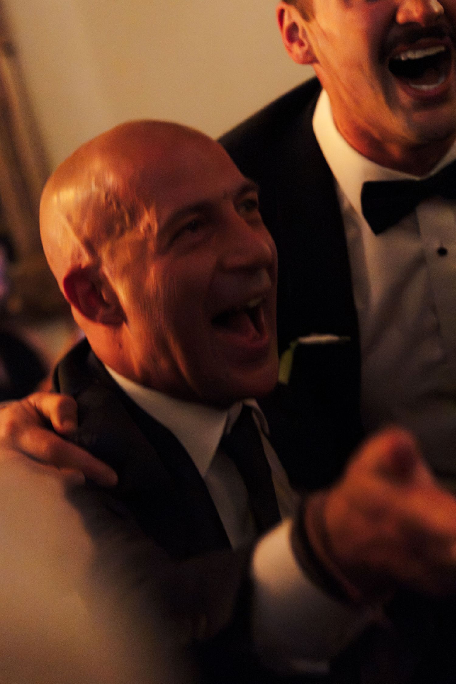 Candid shots of guests laughing during a formal evening wedding reception.