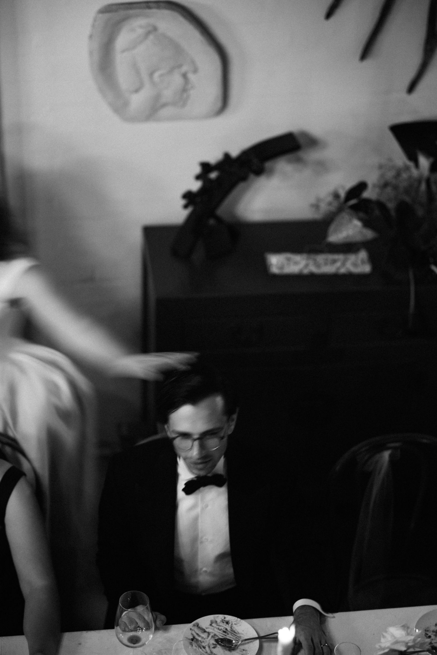 Black and white candid photo showing guests enjoying a reception dinner.