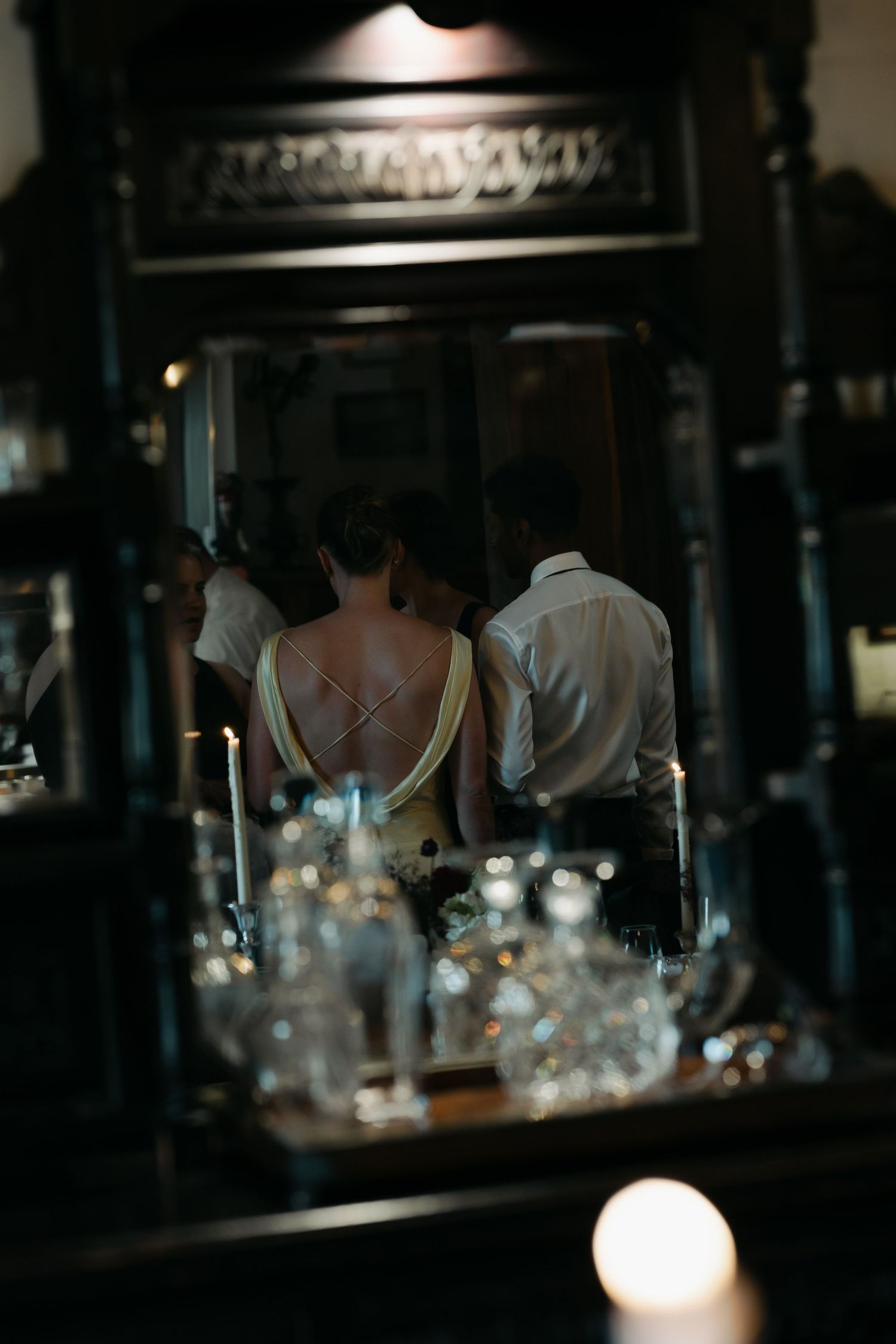 Dimly lit interior bar scene with glassware silhouettes.