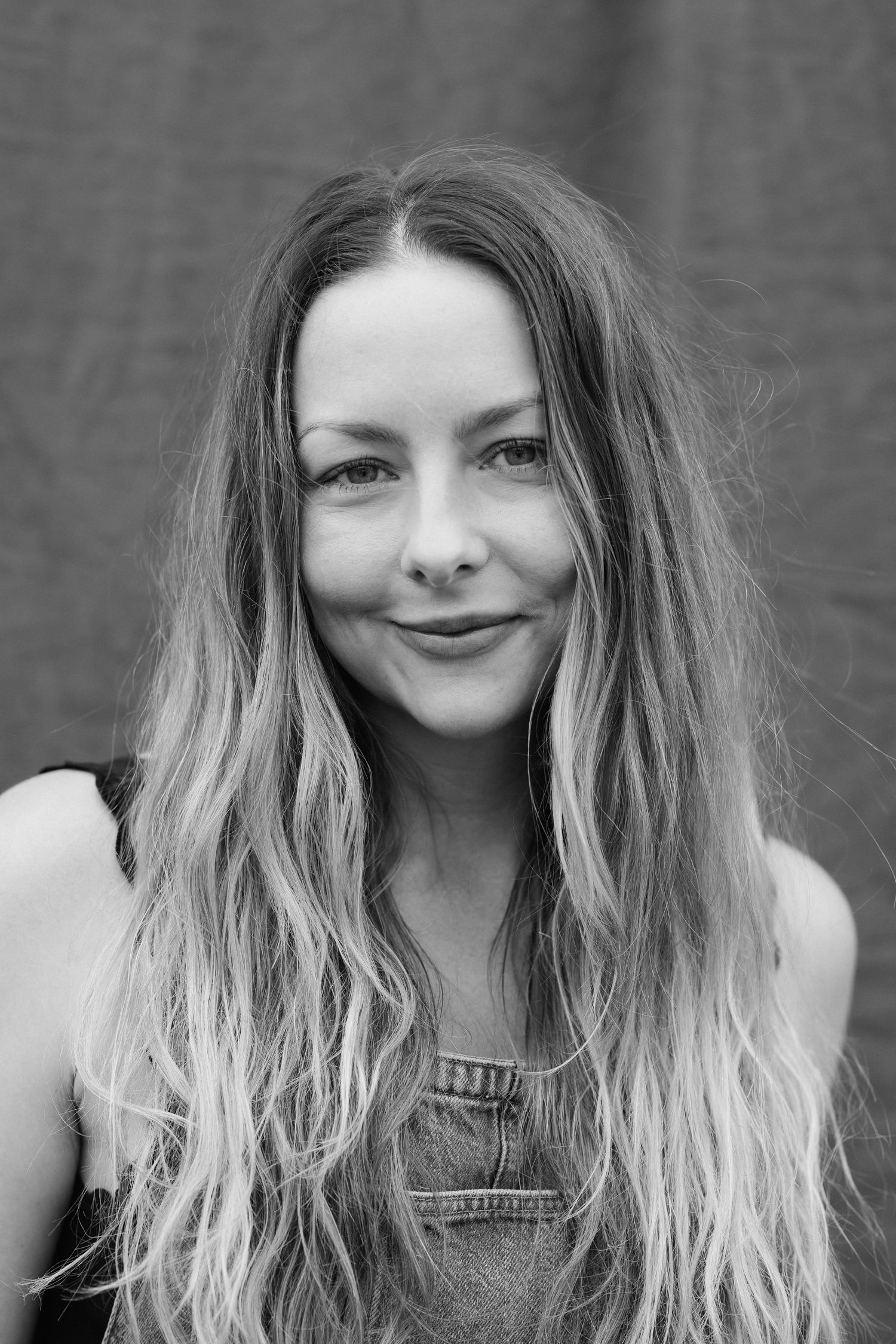 Black and white portrait with natural wavy hair and casual style.