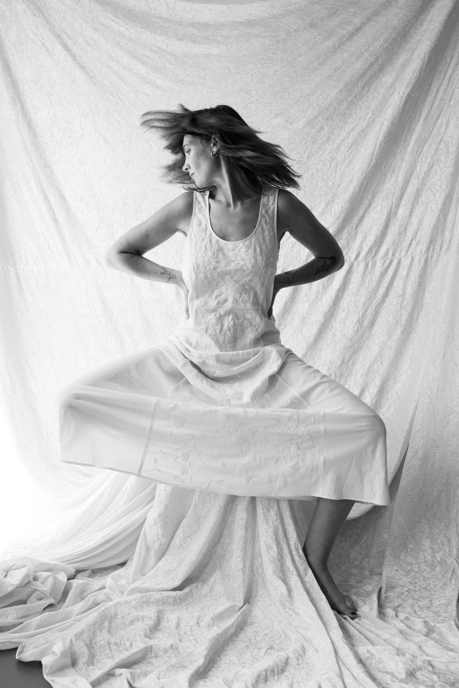 Dynamic sequence of spinning in white dress against white backdrop.