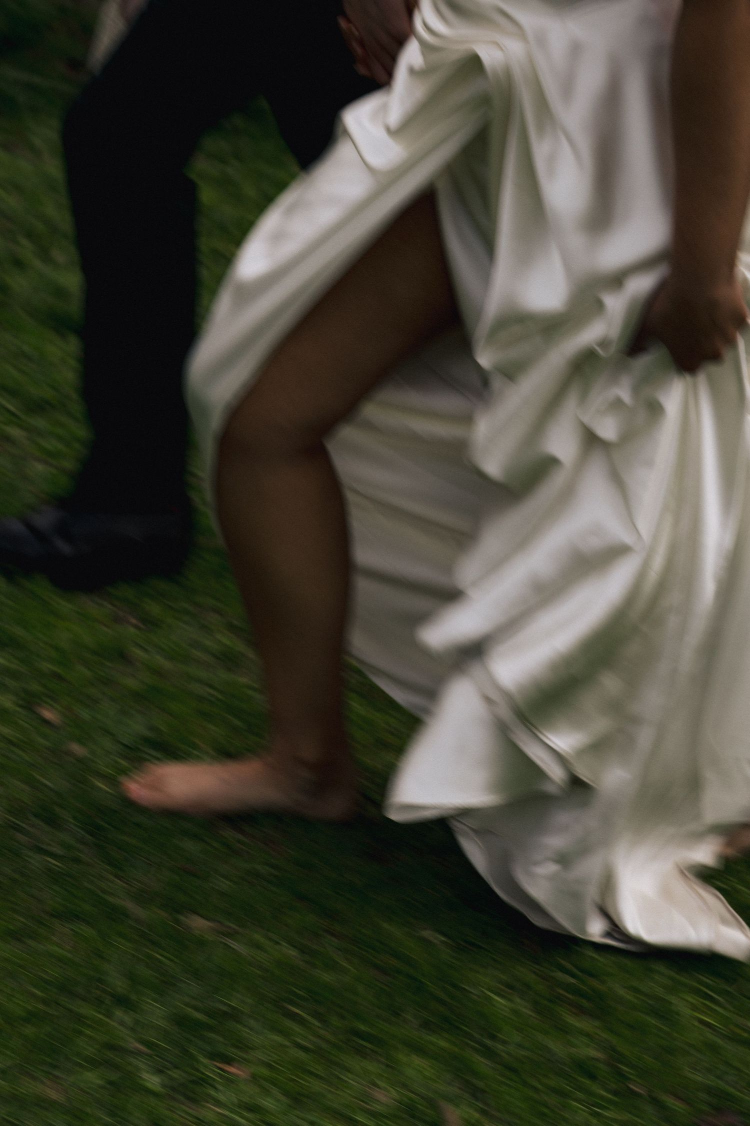 Detail shots of flowing white wedding dress fabric against green grass.