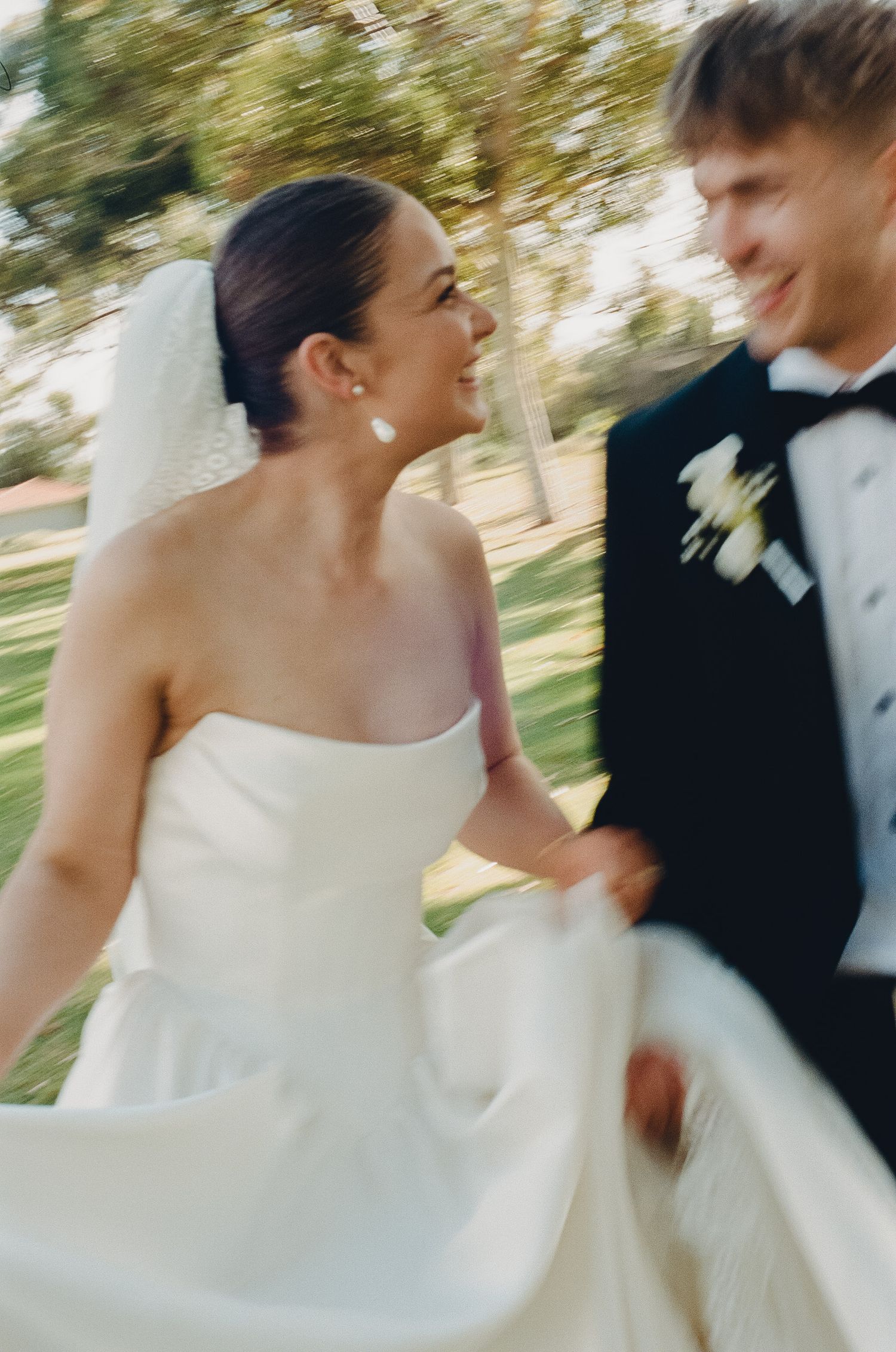 Newlyweds share a playful spinning dance moment outdoors.
