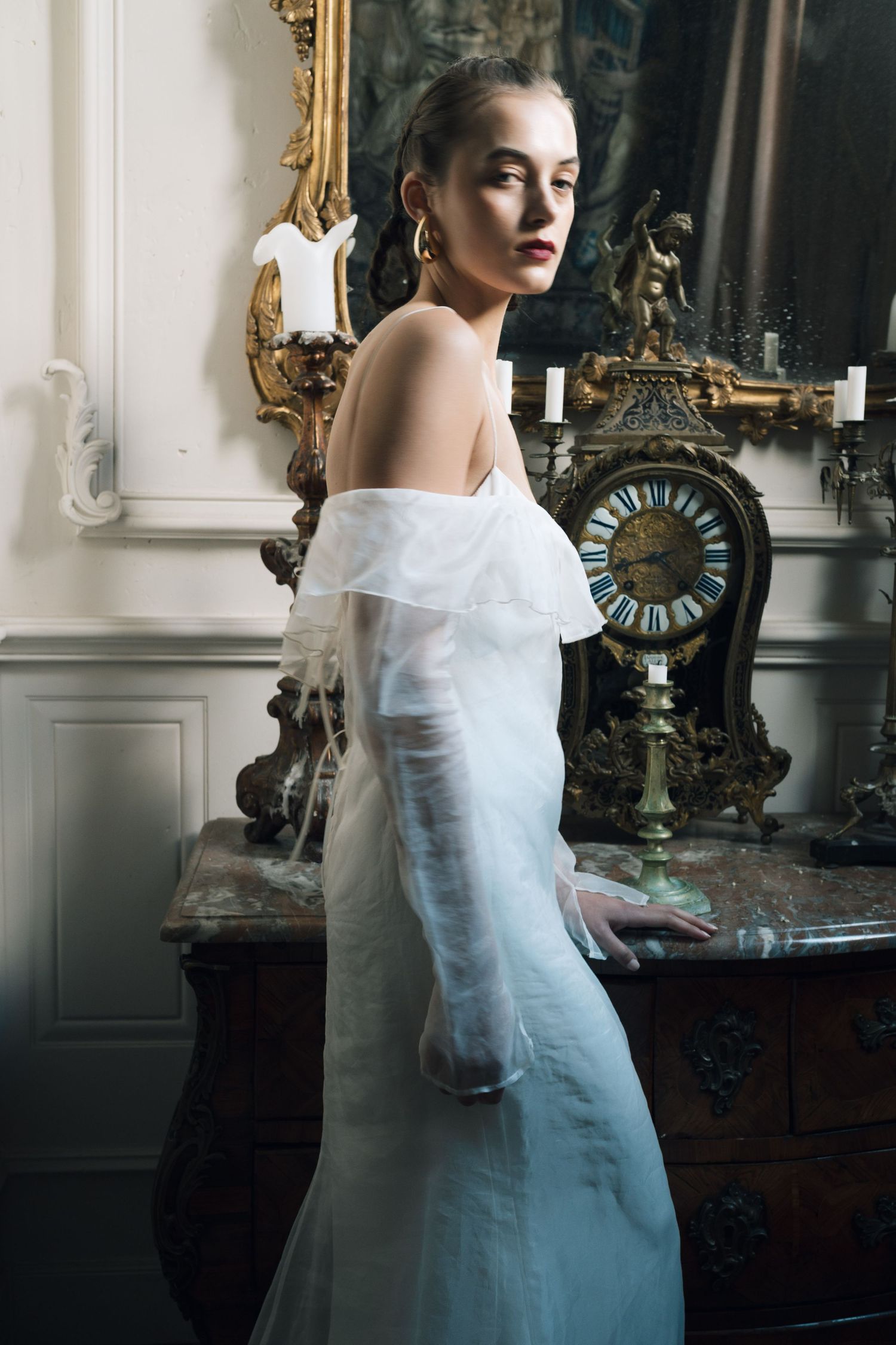 Elegant bridal portrait in a vintage room with ornate mirrors and decor.