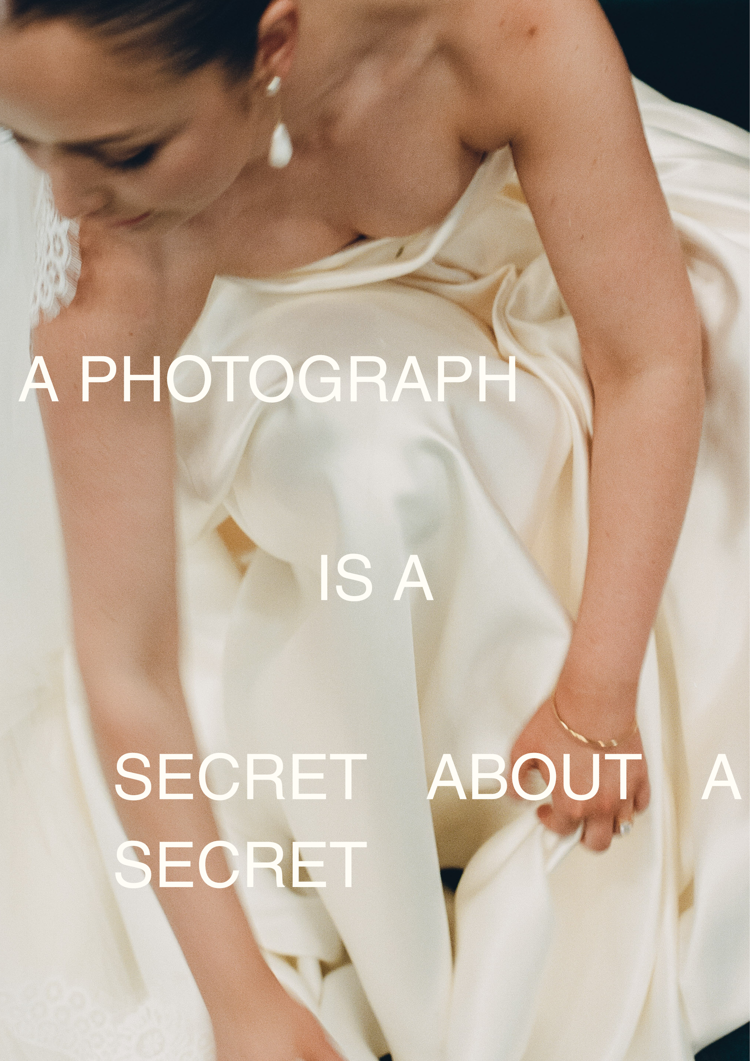Woman in elegant ivory satin gown with text overlay reading a photograph is a secret about a secret.