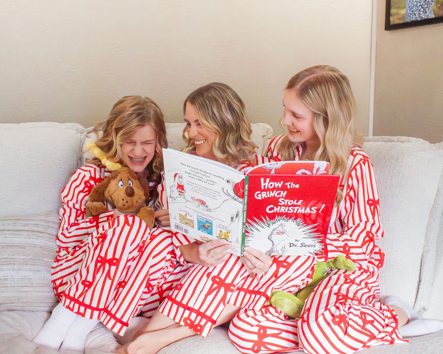 A cozy scene of people in matching red and white striped pajamas lounging on a bed.
