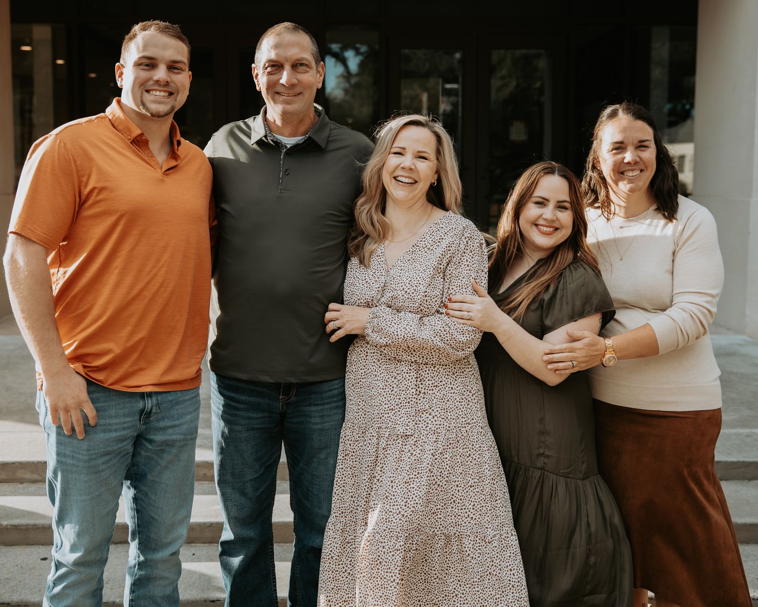 Family portrait session outdoors with coordinated casual outfits in earth tones.