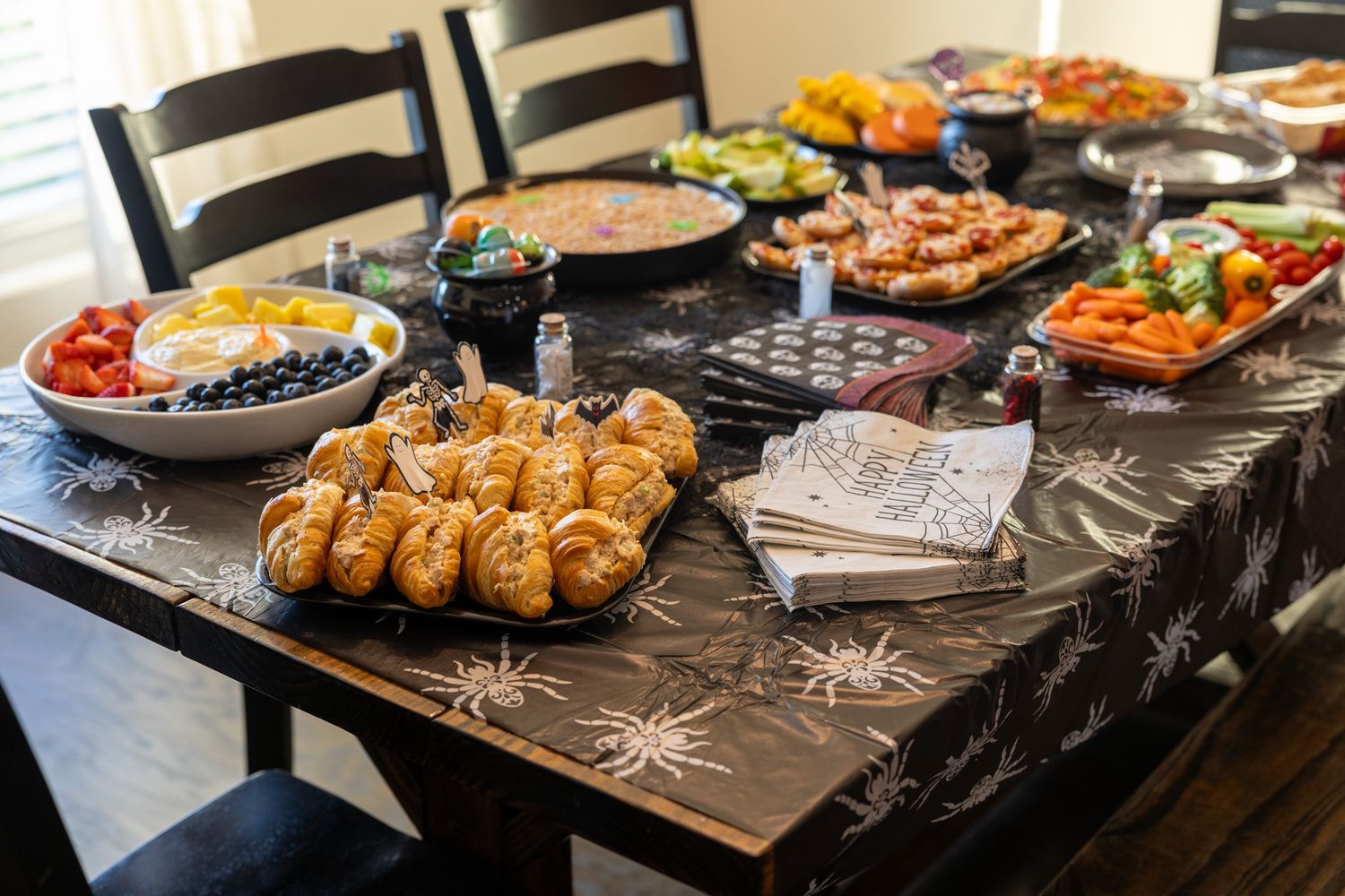 A buffet spread of various appetizers and dishes displayed on dark slate platters at a catering event.