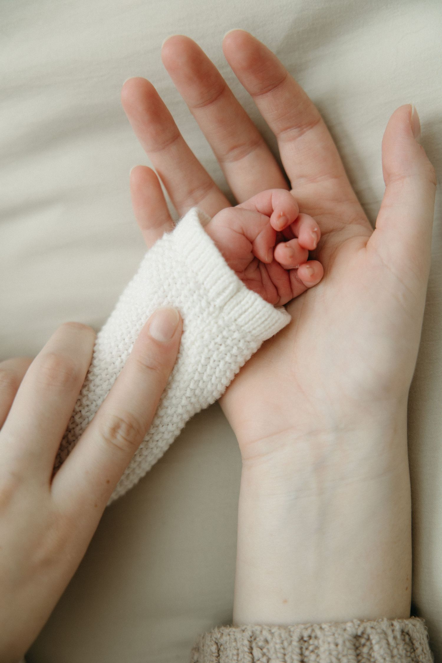 A series of hands holding and wrapping a white bandage or gauze around a wrist against a light background.