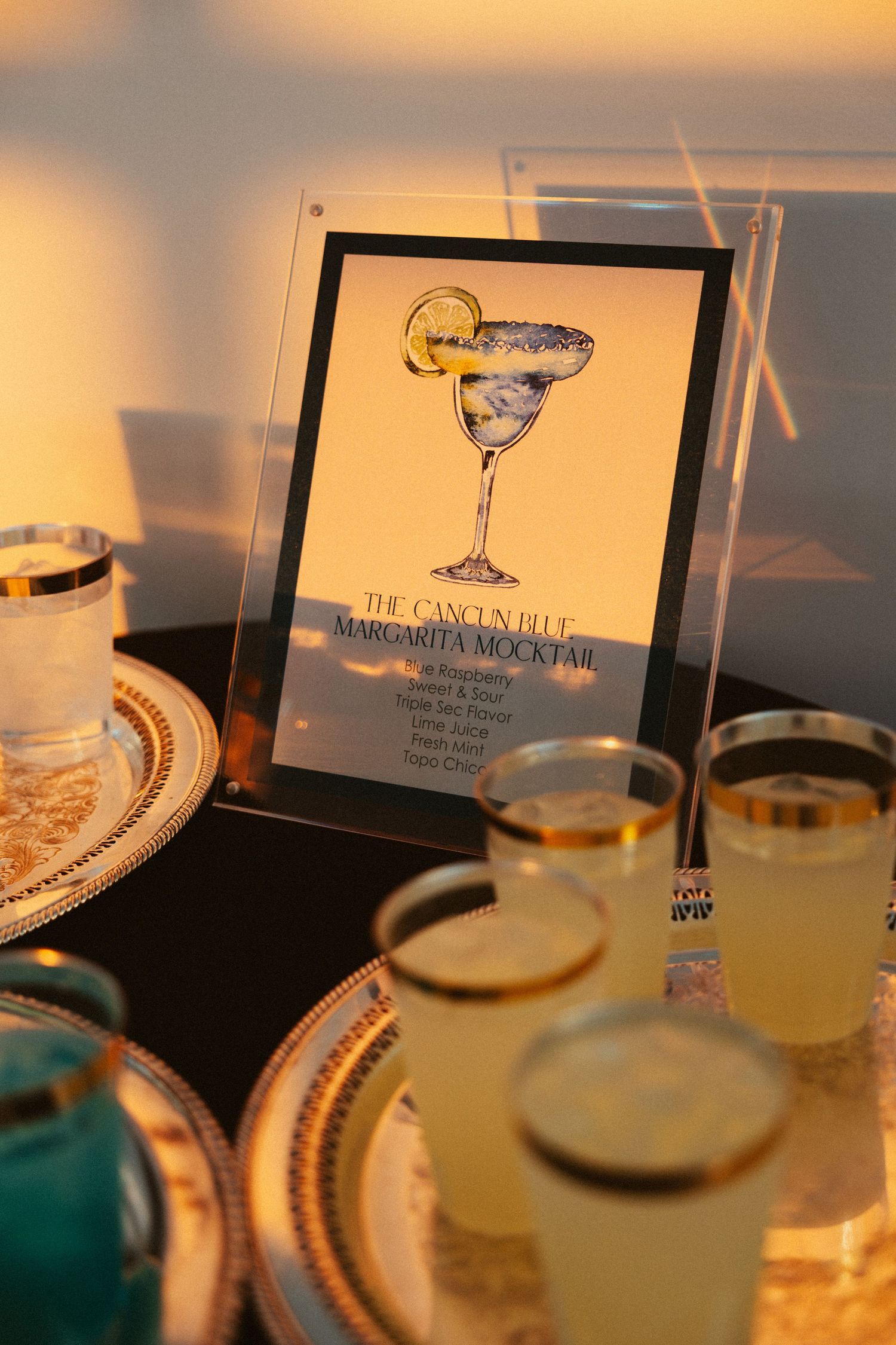Elegant cocktail glasses with menu cards on a table illuminated by warm ambient lighting at a luxury bar setting.