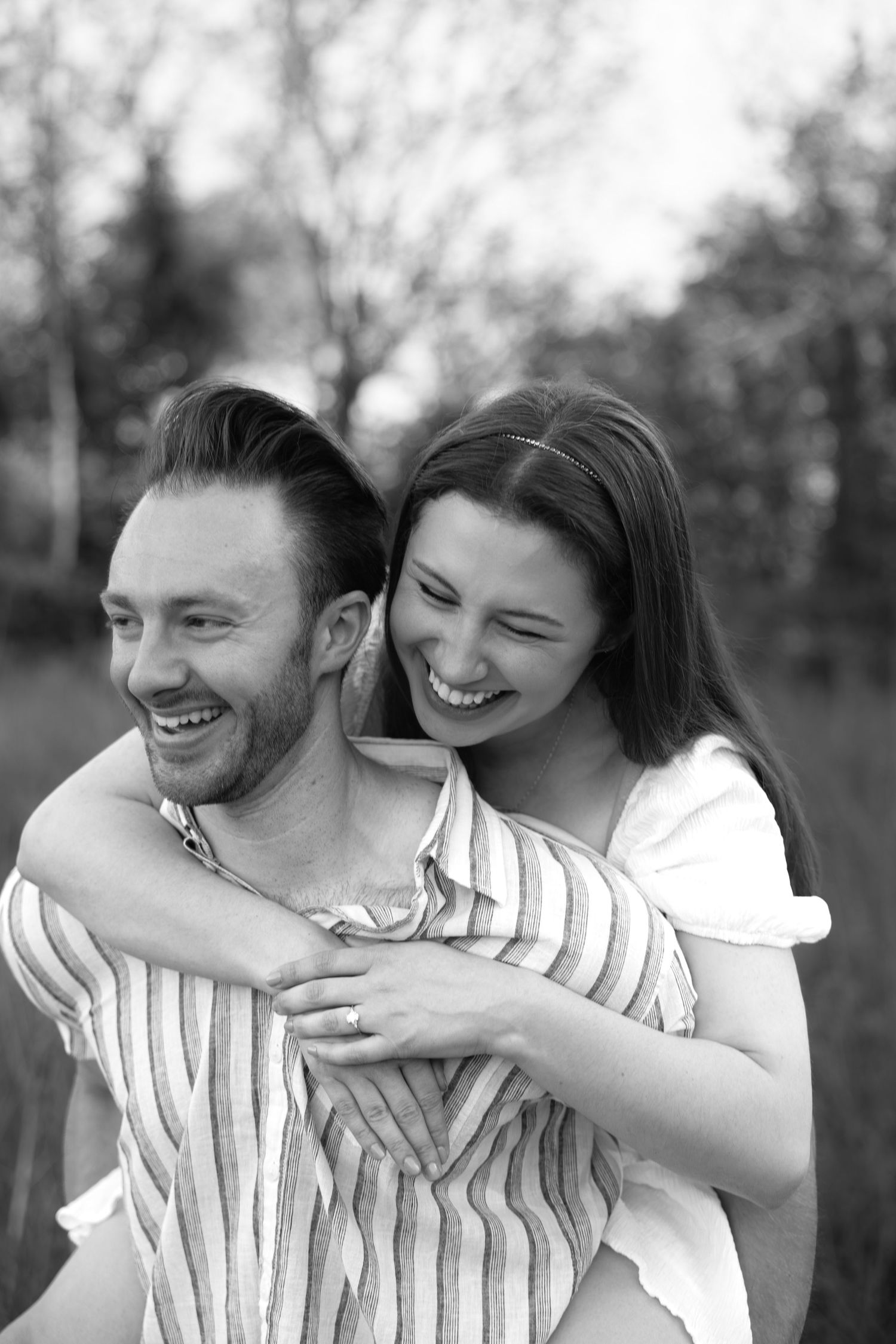 A playful black and white photo series showing a couple embracing and laughing together outdoors.