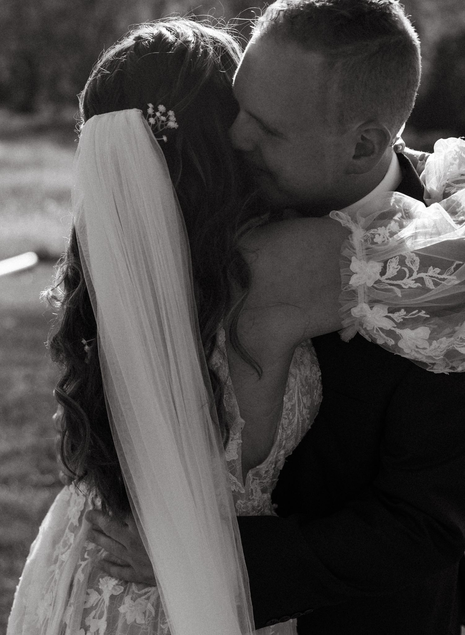 Black and white intimate moment between newlyweds with veil detail.