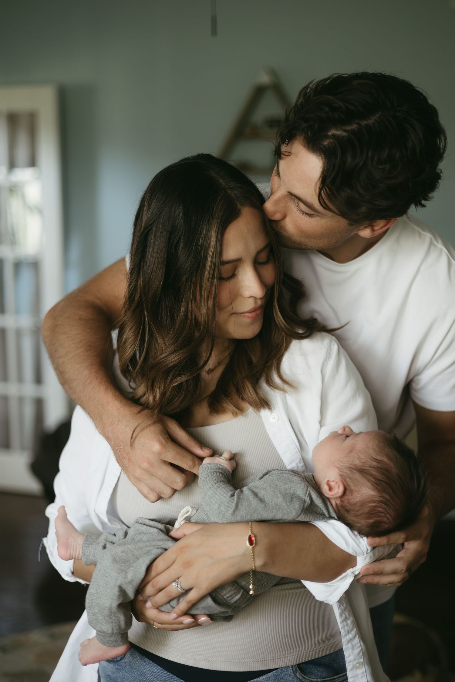 A series of intimate photographs showing tender moments between a couple and their newborn baby.