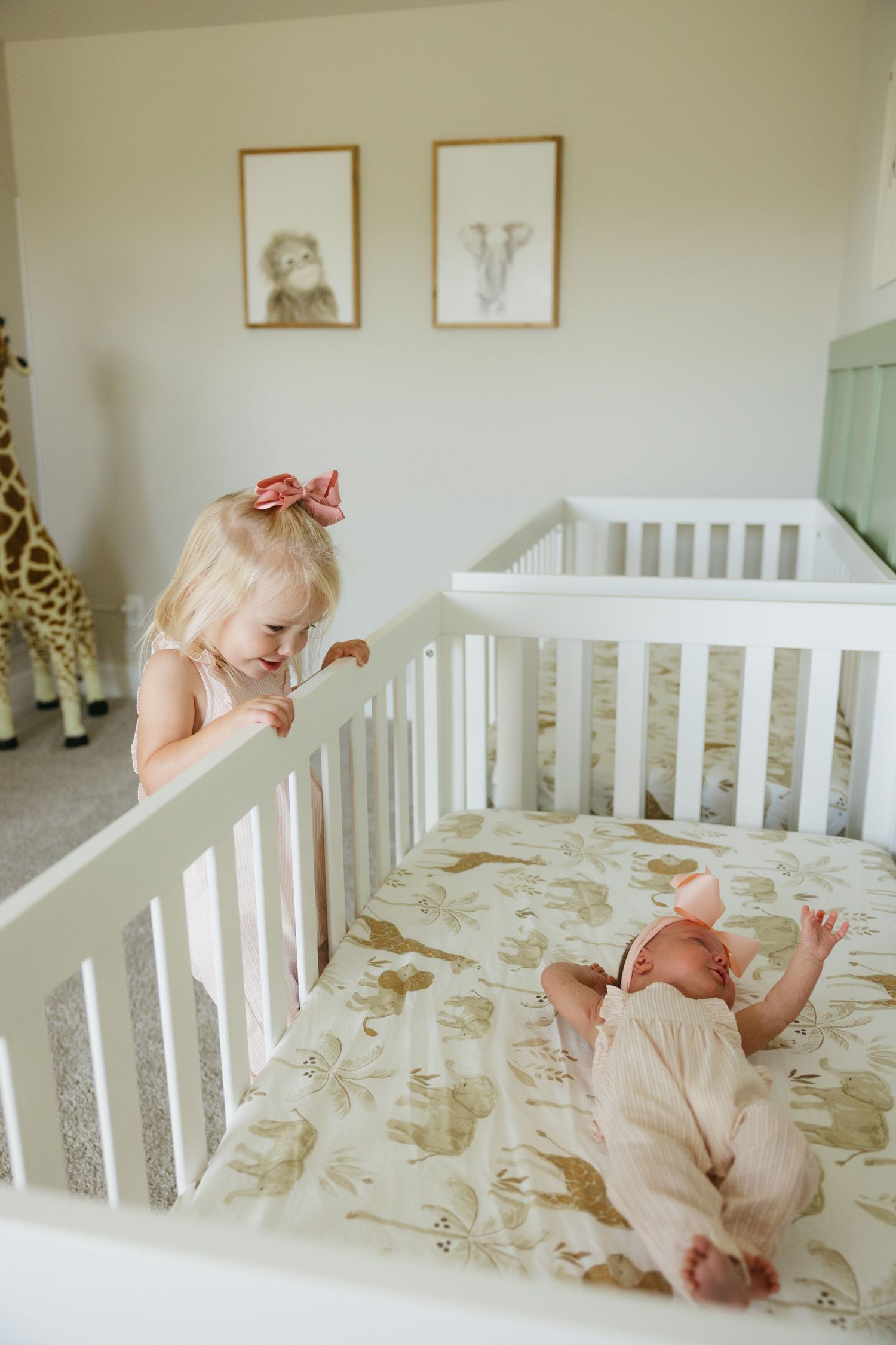 Series of images showing siblings bonding and playing together on a white crib with floral bedding.