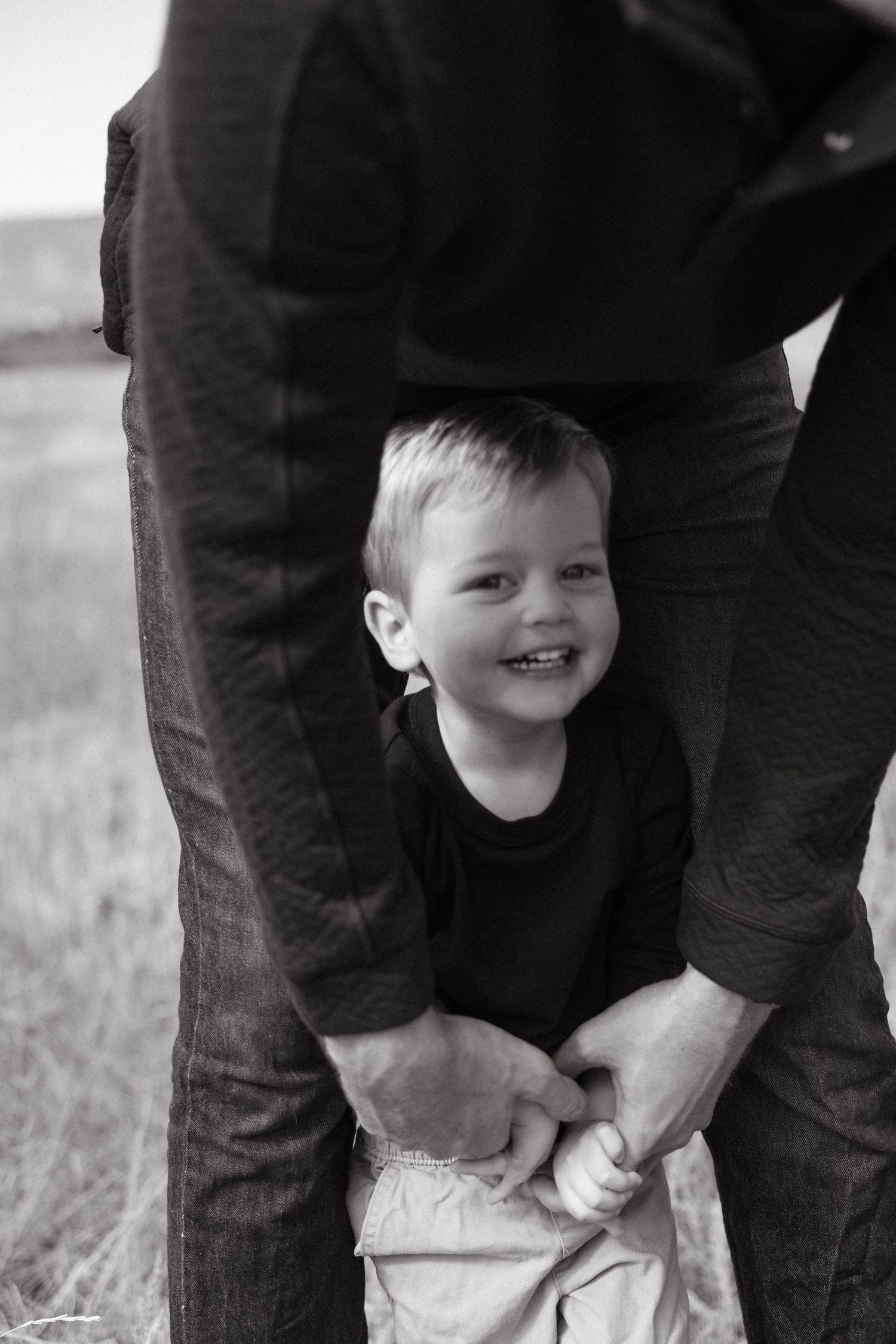 Black and white photo series showing close-up details of a child's feet being helped into shoes by adult hands.