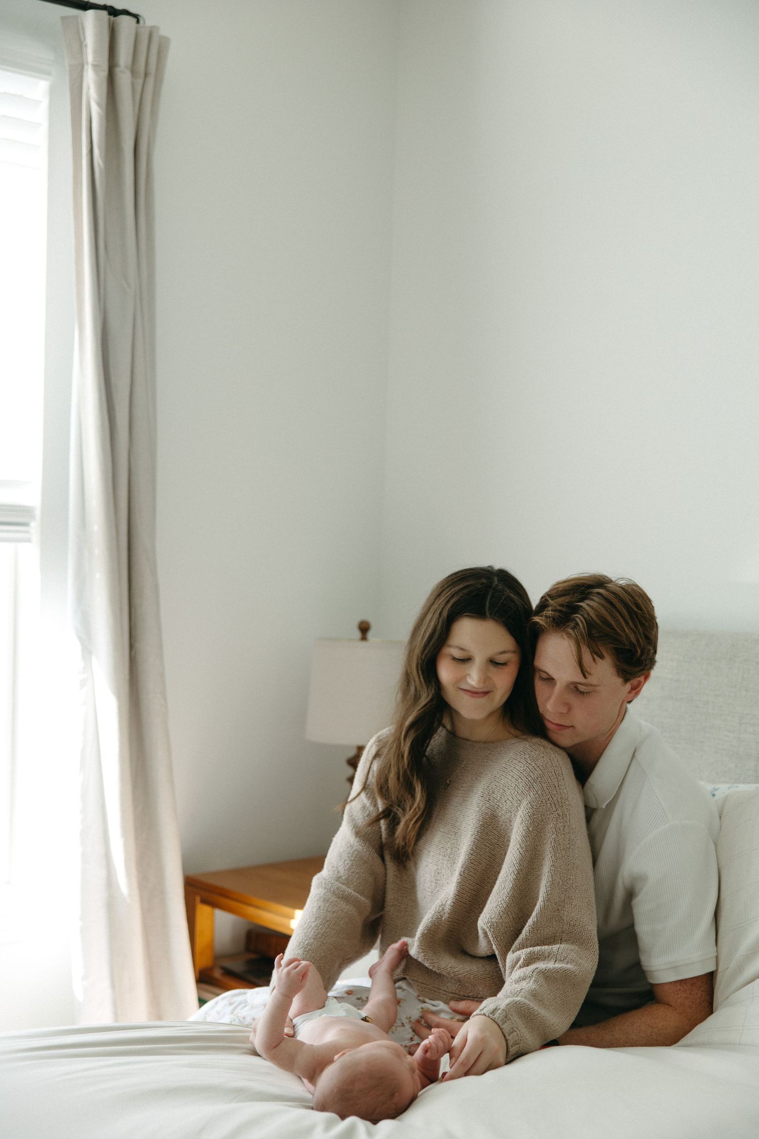 Family sharing tender moment together on white bed.