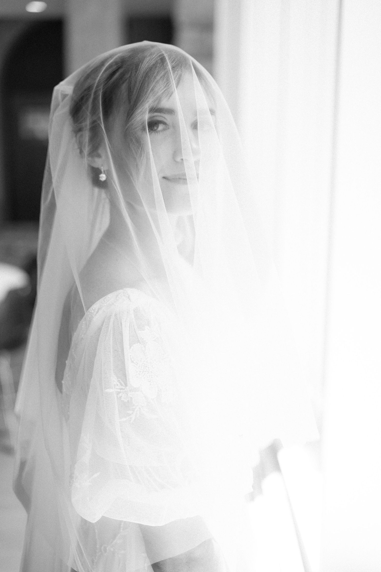 Close-up artistic shots of a delicate white bridal veil in natural light.