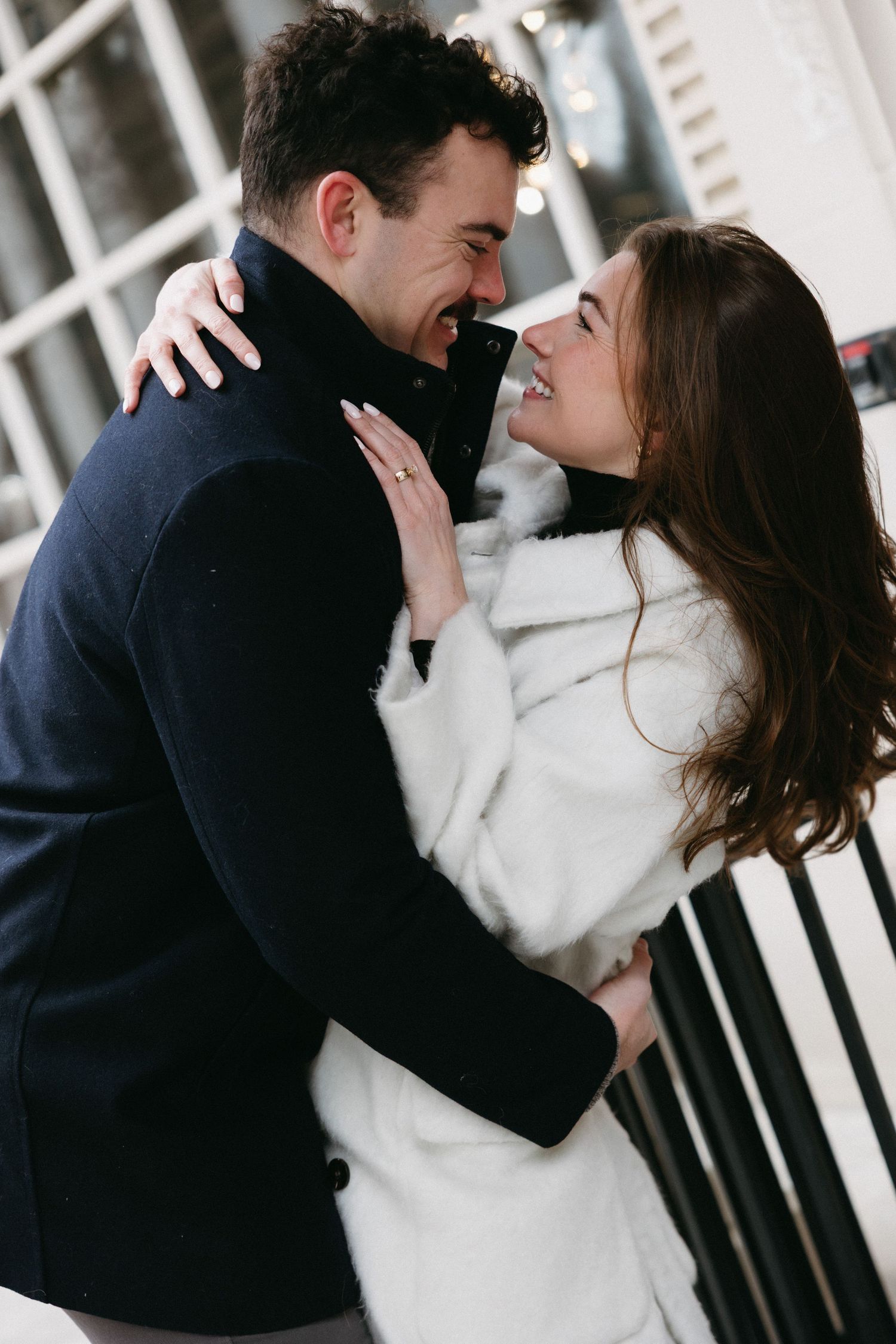 A sequence of intimate moments between a couple in winter coats against a white background.