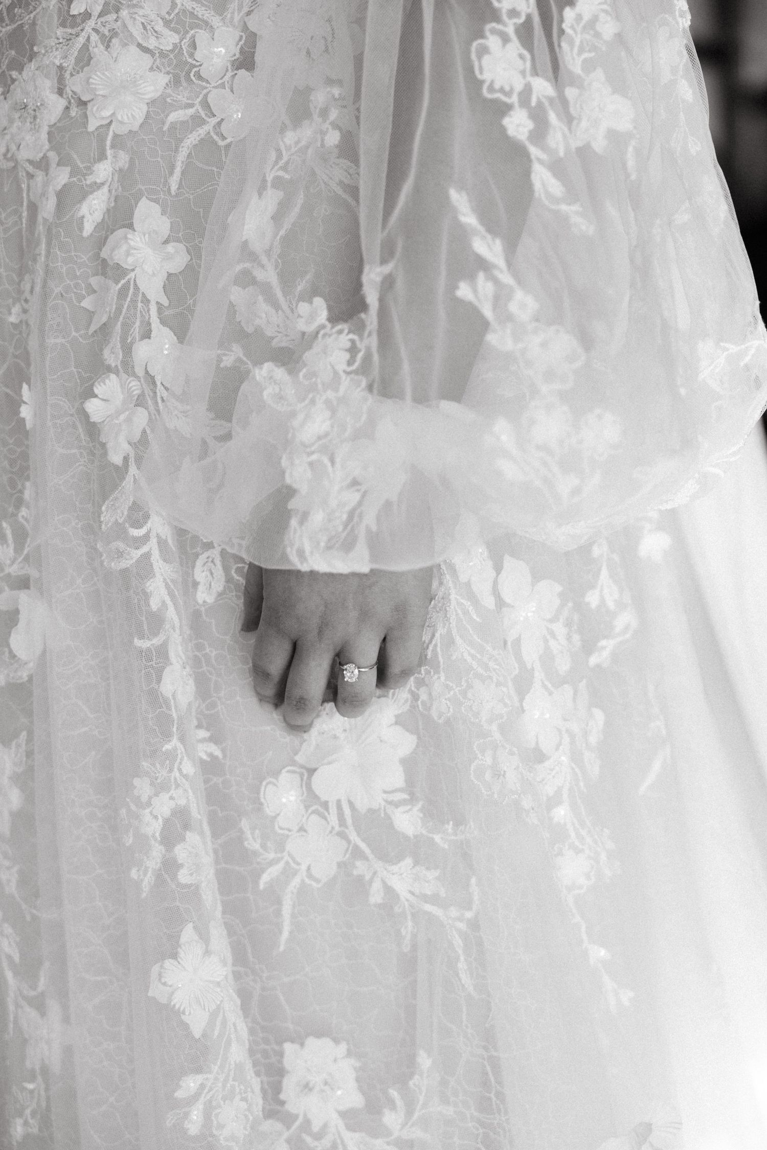 Close-up details of delicate lace patterns on a white wedding dress.