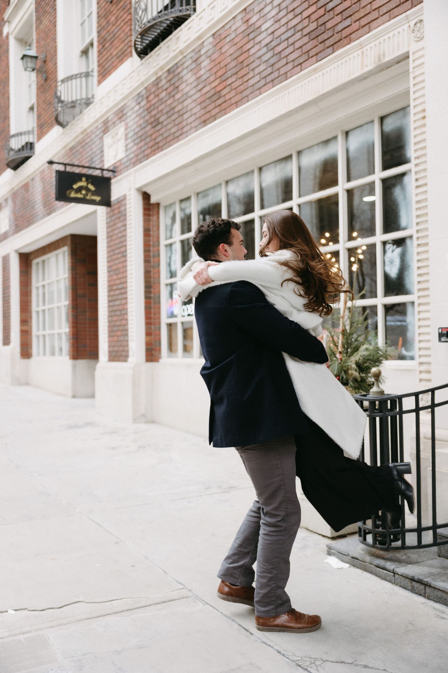A sequence of romantic photos showing a couple embracing outside a brick building with white trim.