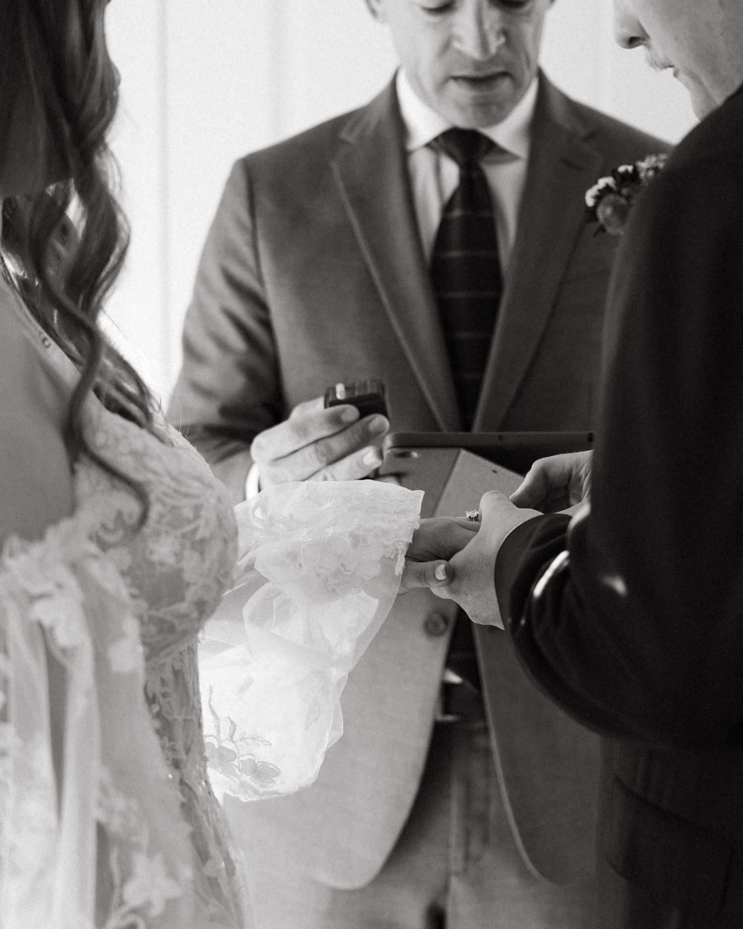 Black and white image of hands holding and opening a folded paper note in sequence.