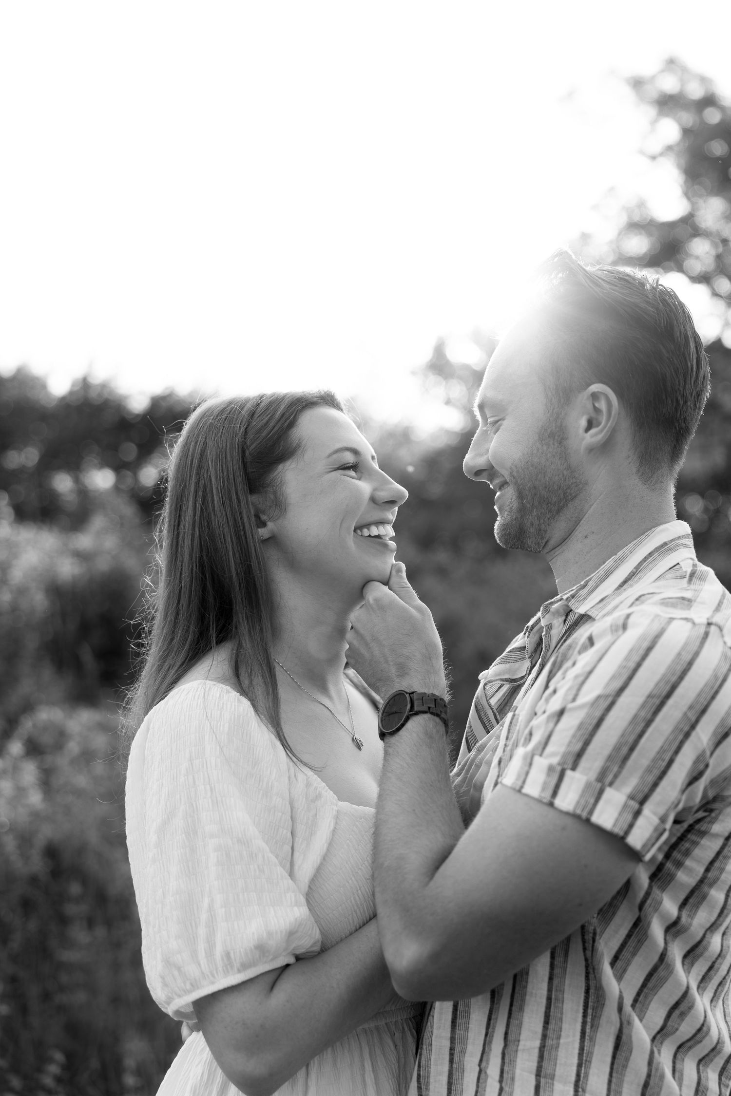 Joyful couple sharing intimate moment while dancing in summer field.
