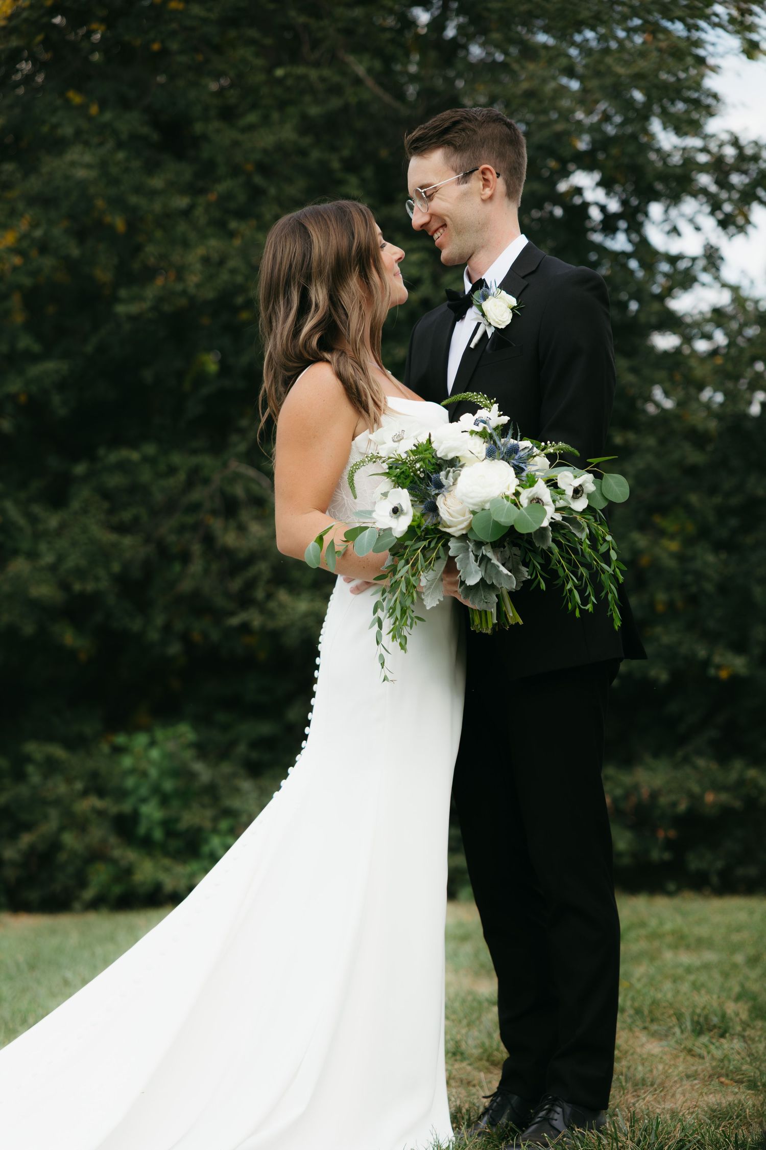 Romantic wedding photo series showing tender moments between couple in outdoor garden setting with white floral bouquet.