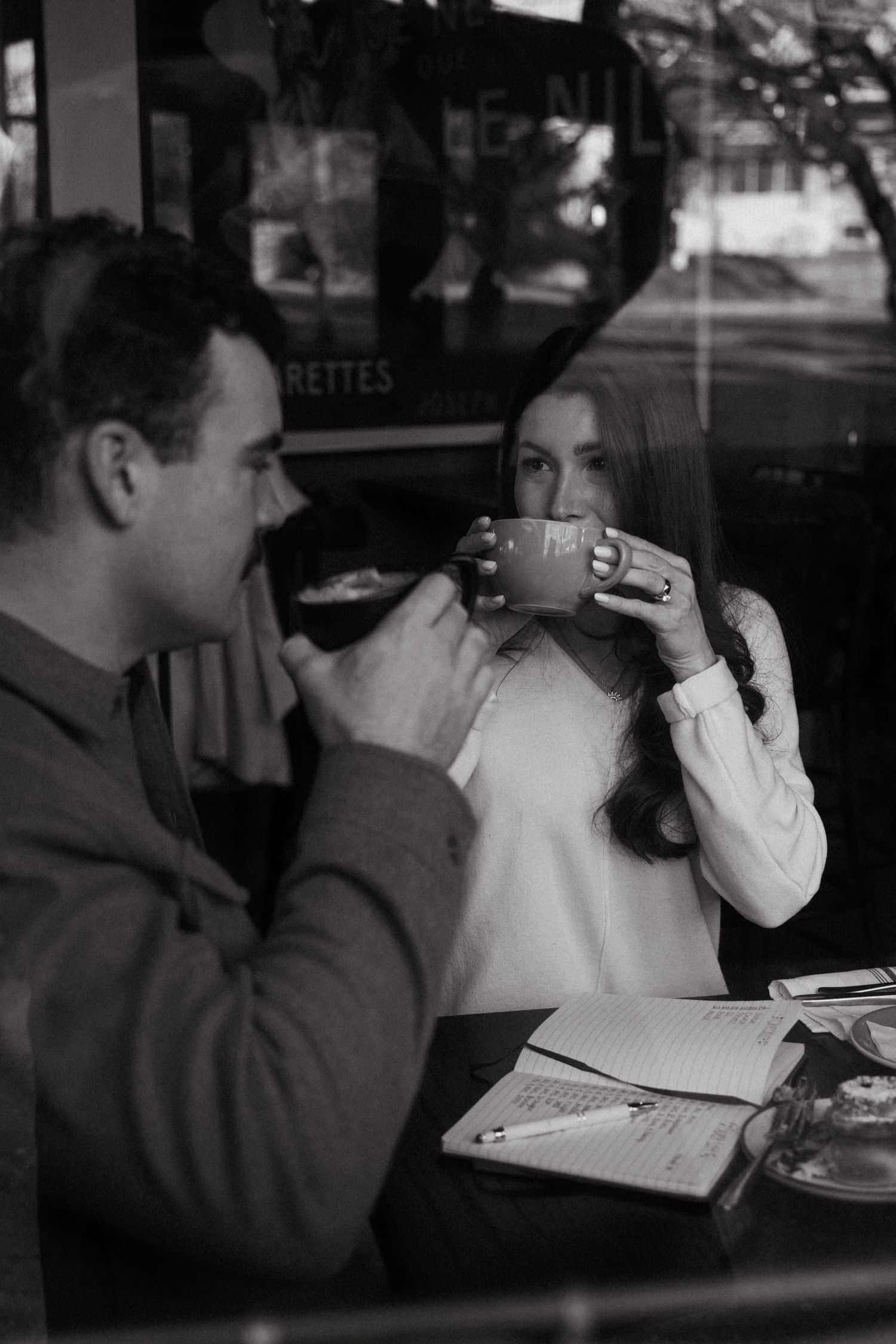 Black and white sequence showing two people sharing drinks at a cafe counter.