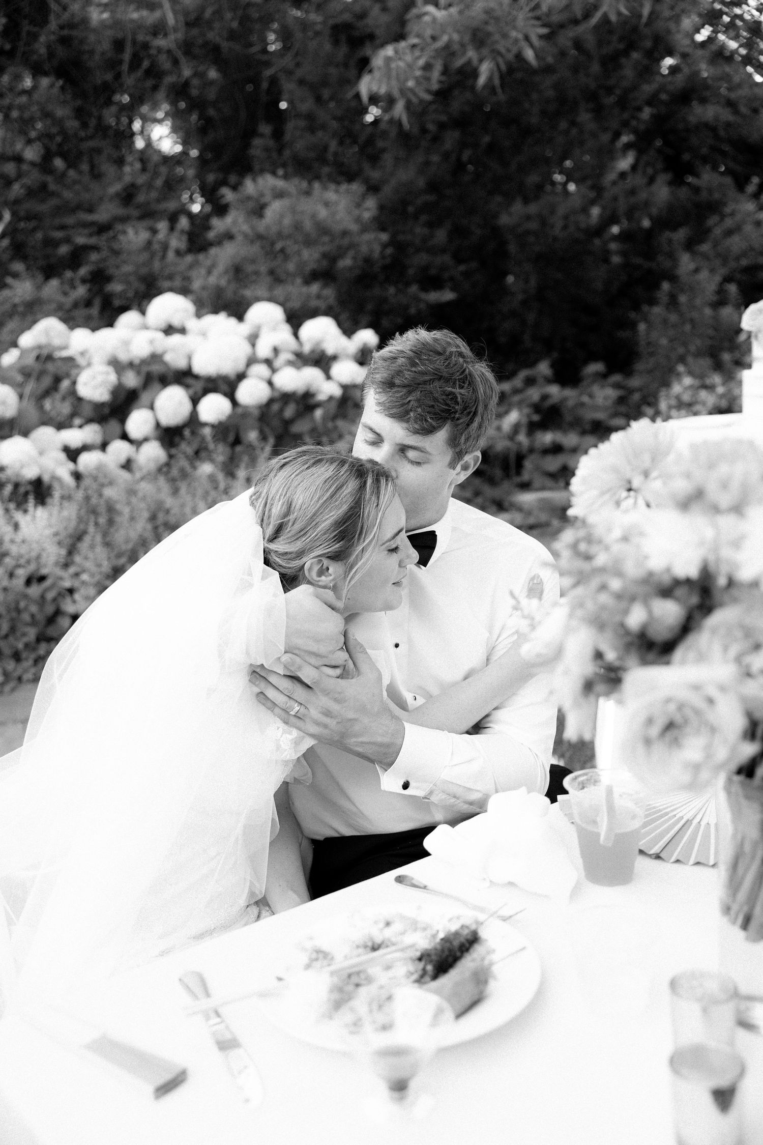Black and white wedding portrait sequence in an outdoor garden setting.