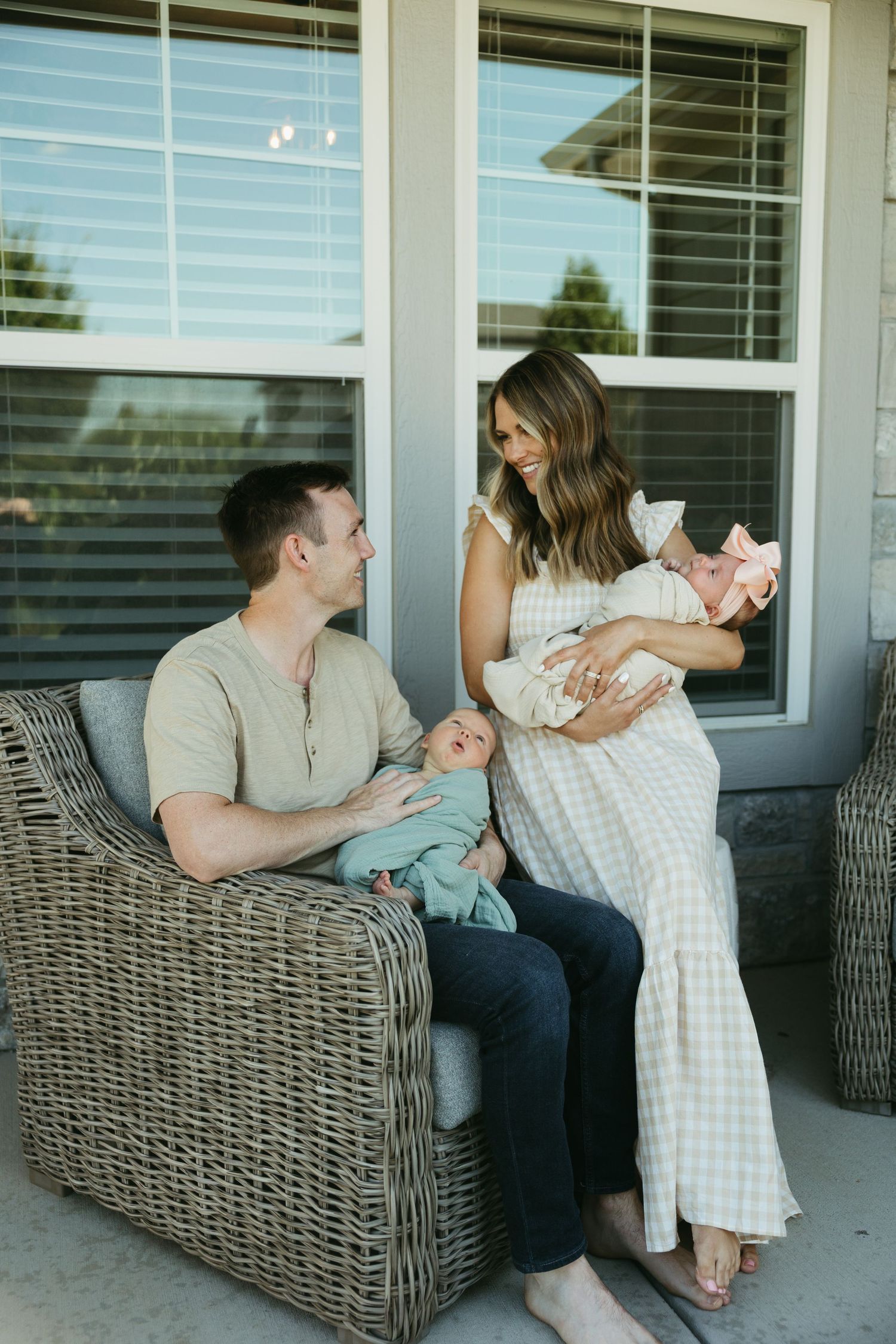 A family shares tender moments together while relaxing on a wicker patio sofa.