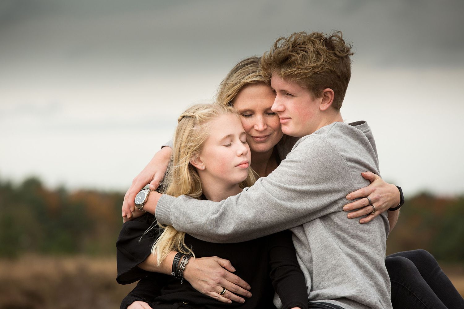 Familj som kramas under en avslappnad fotografering utomhus i Dalsland