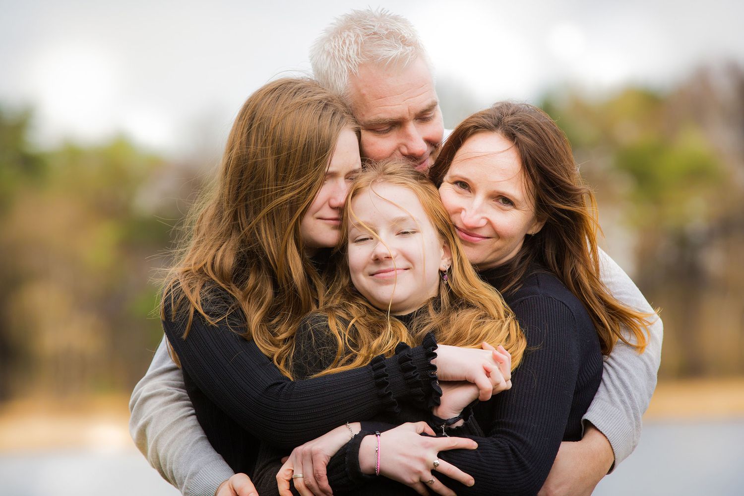 Familj tillsammans utomhus under en naturlig familjefotografering i Dalsland