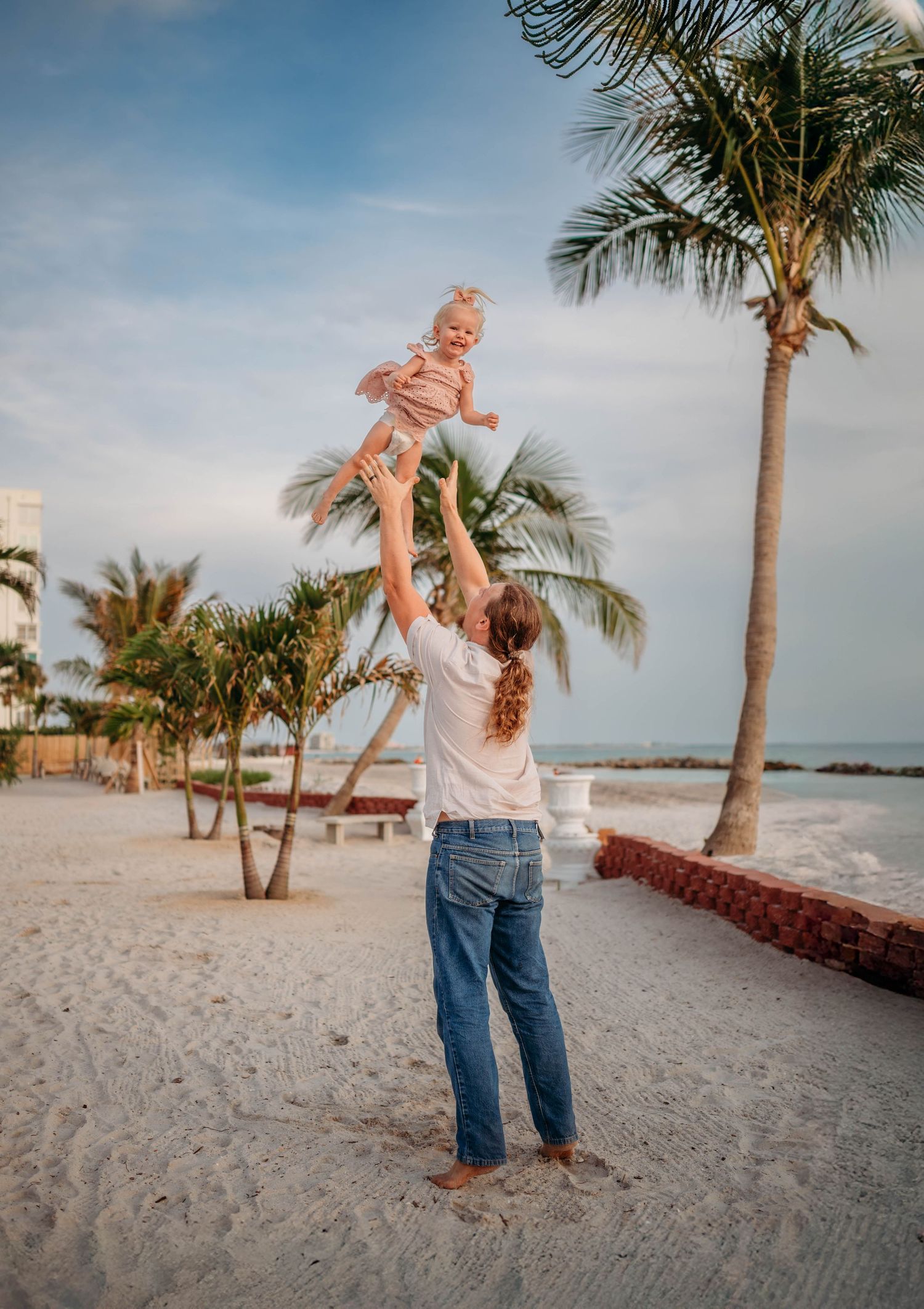 Joyful moments shared on a tropical beach with palm trees and ocean views.