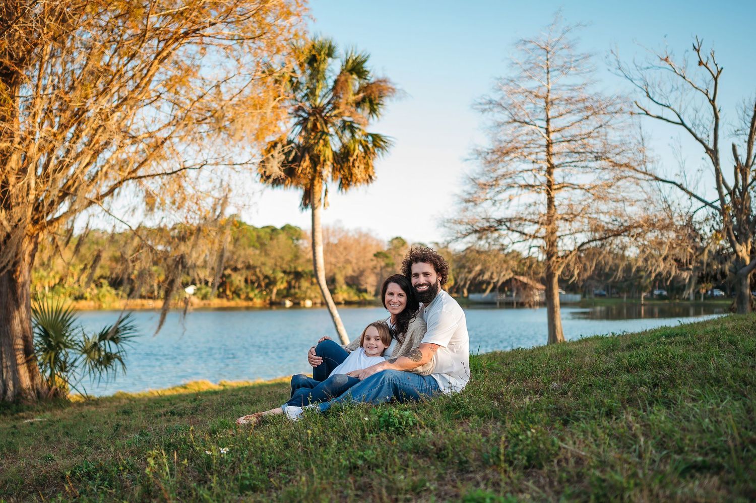 Scenic panoramic view of a family gathering by the lake with fall foliage.