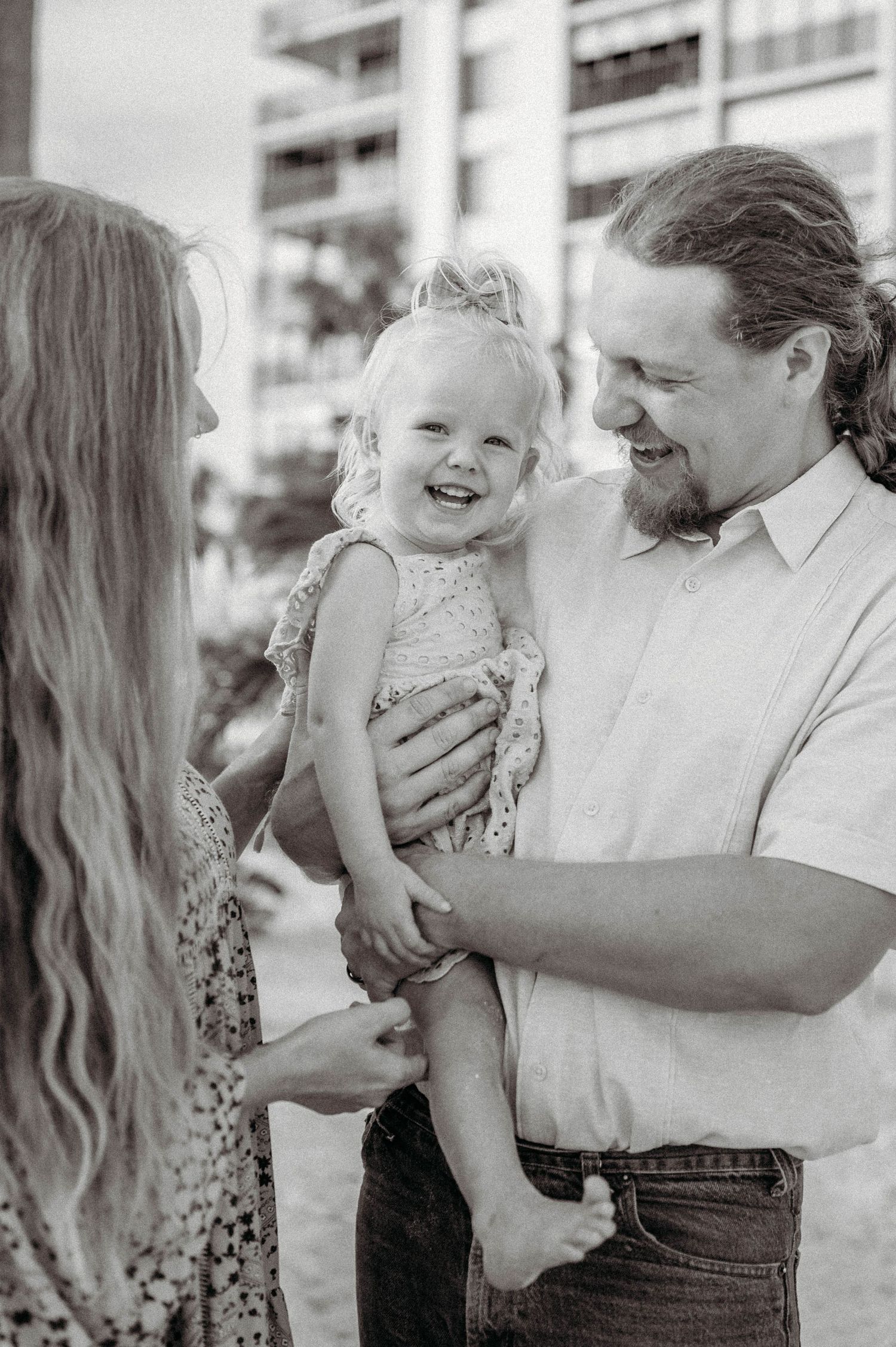 A playful moment of joy and laughter captured in black and white on a sunny day.