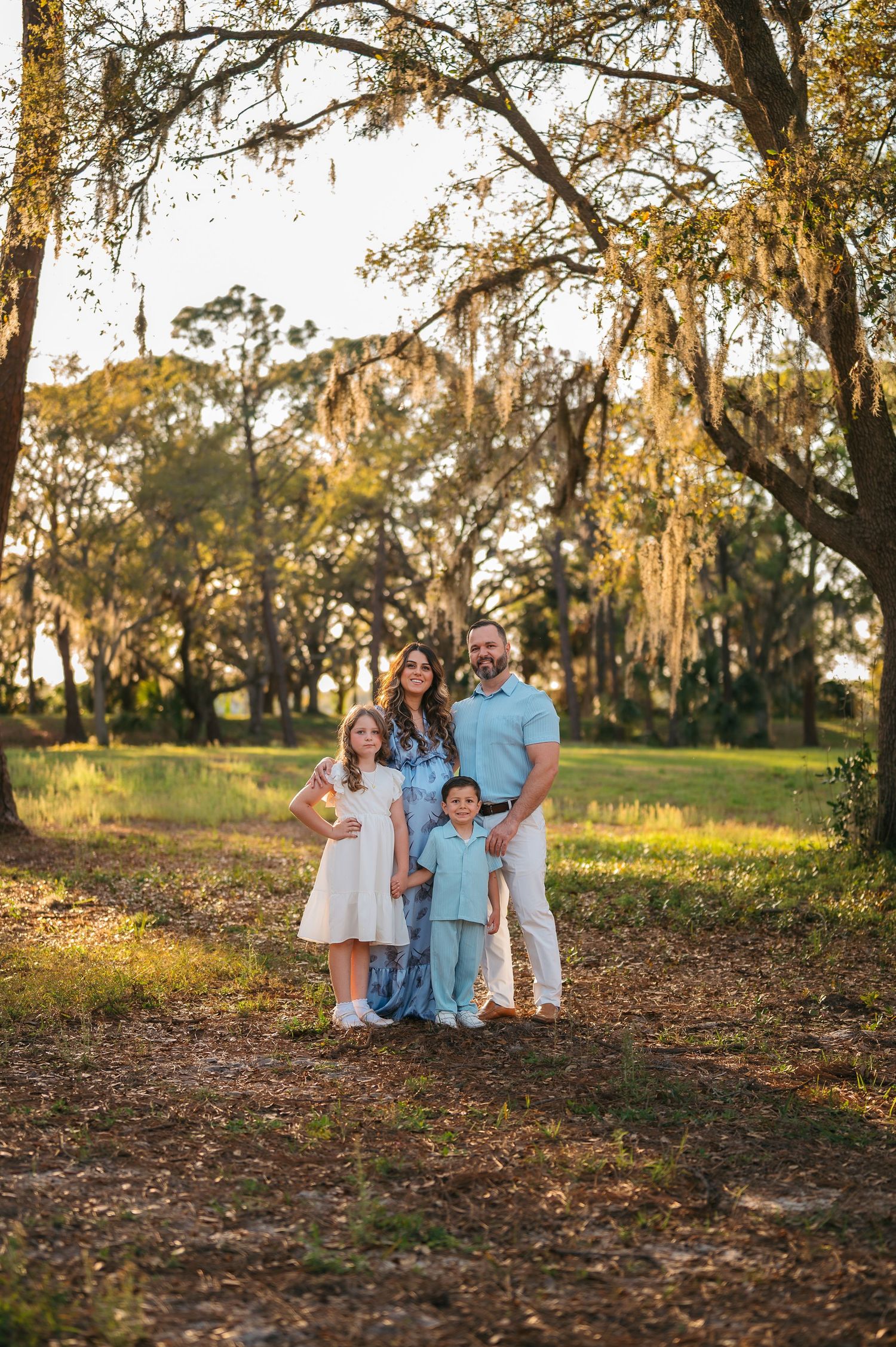 Family portrait under Spanish moss draped trees in golden light.