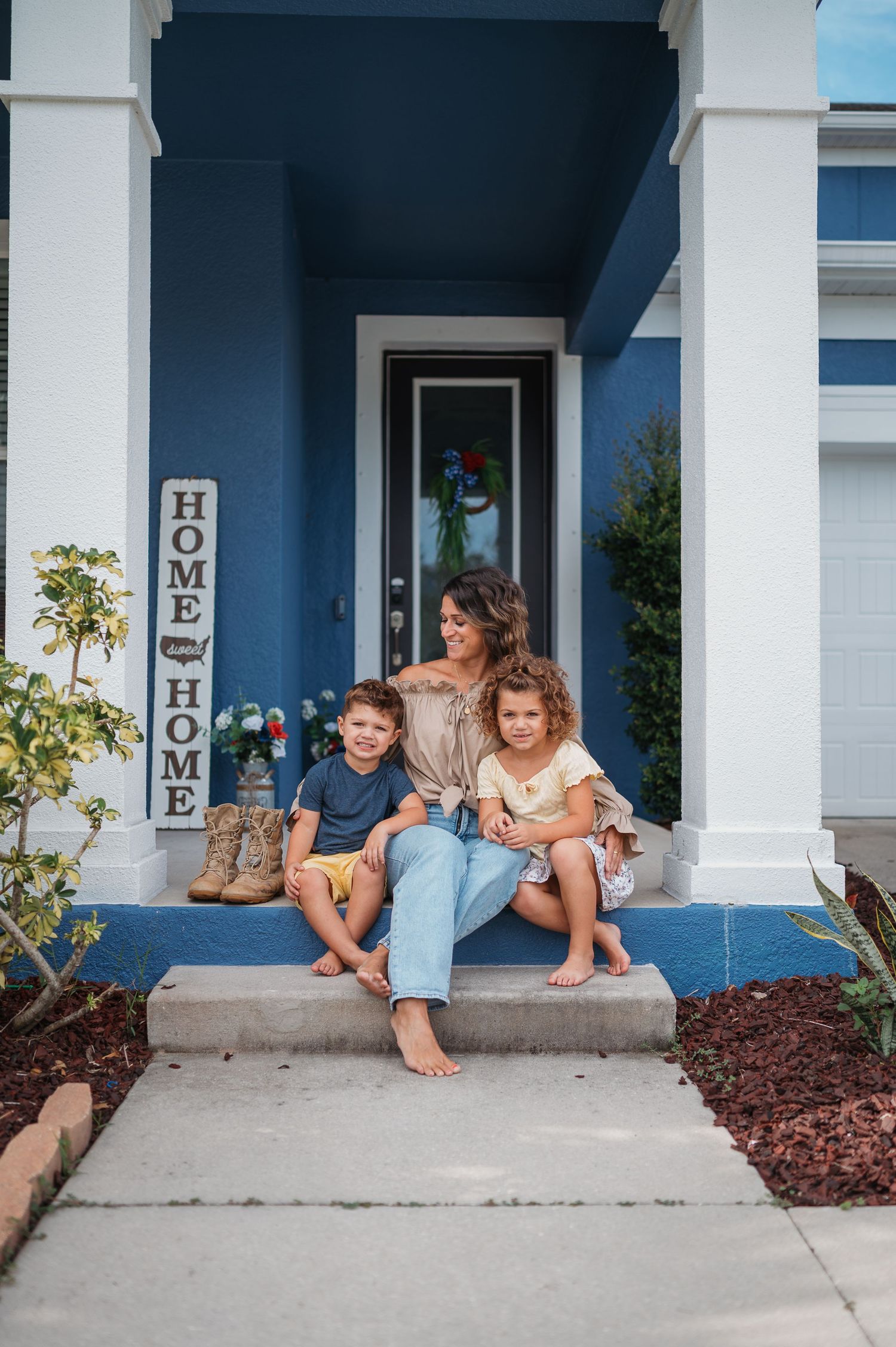 A casual scene on a front porch of a blue house with white pillars.