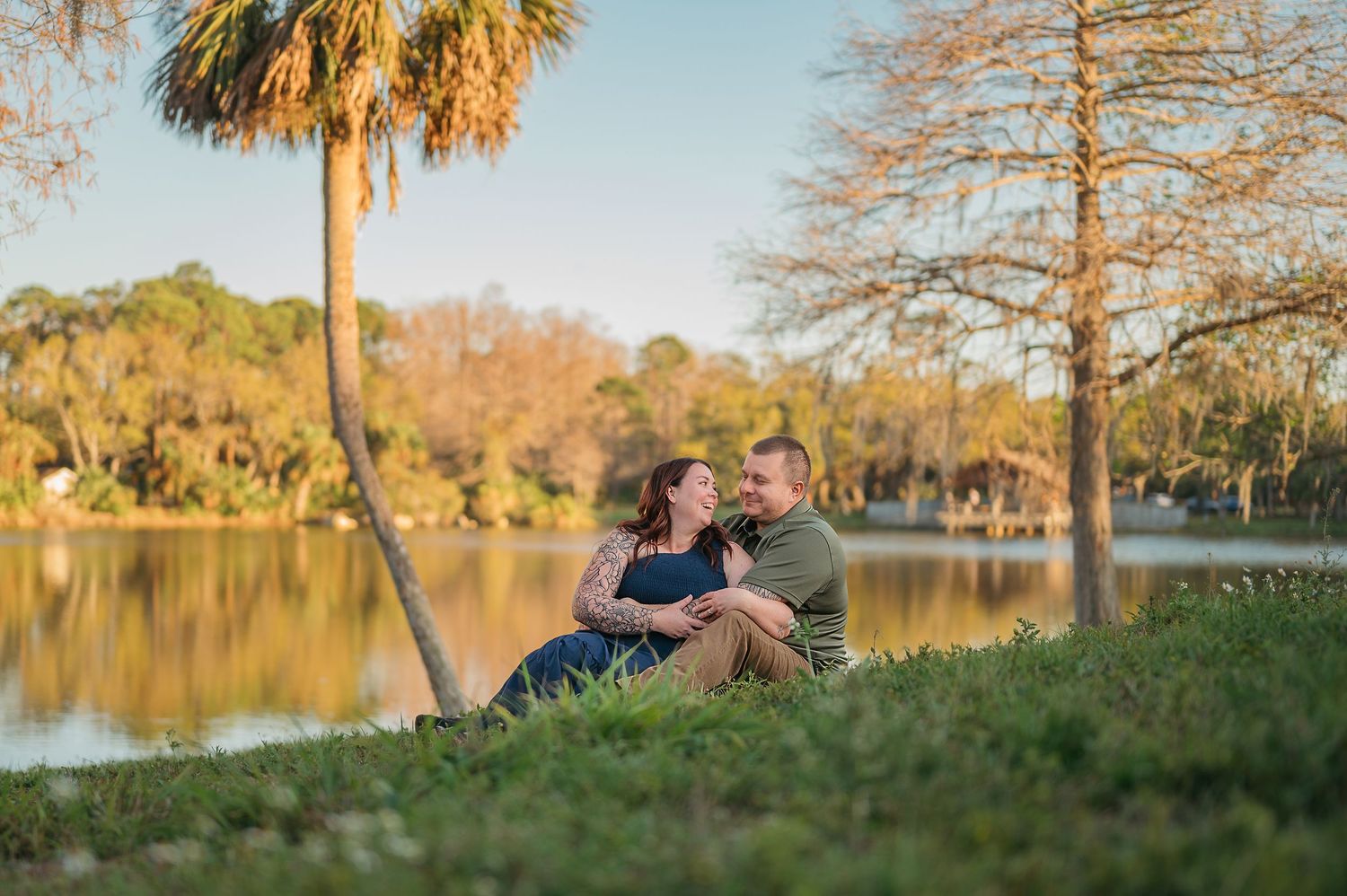 Lakeside photo session during golden hour with palm trees and autumn foliage.