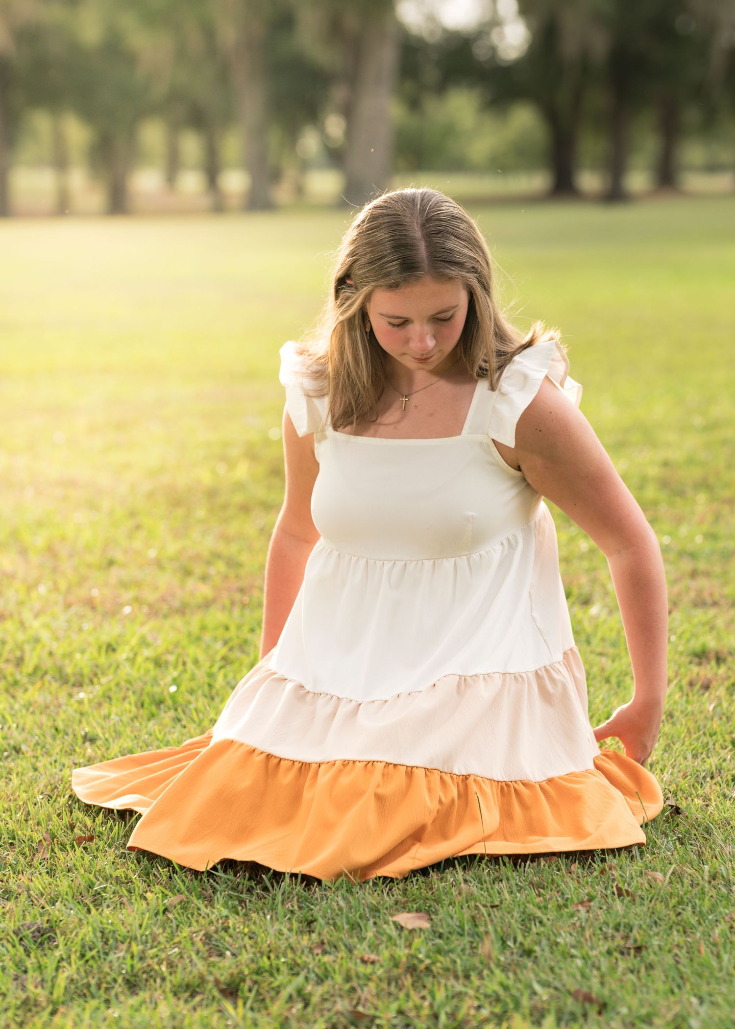 White dress with orange trim shown in multiple close-up detail shots on grass.