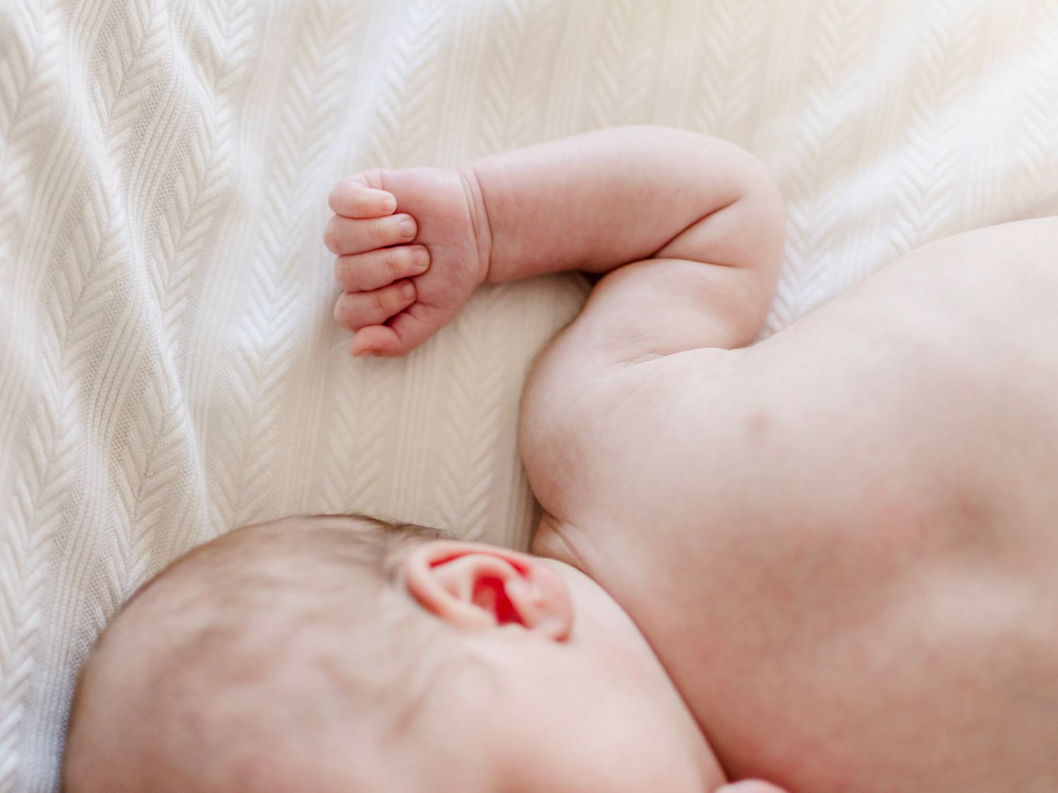 Newborn baby sleeping on cream blanket, lifestyle newborn photography in Essex