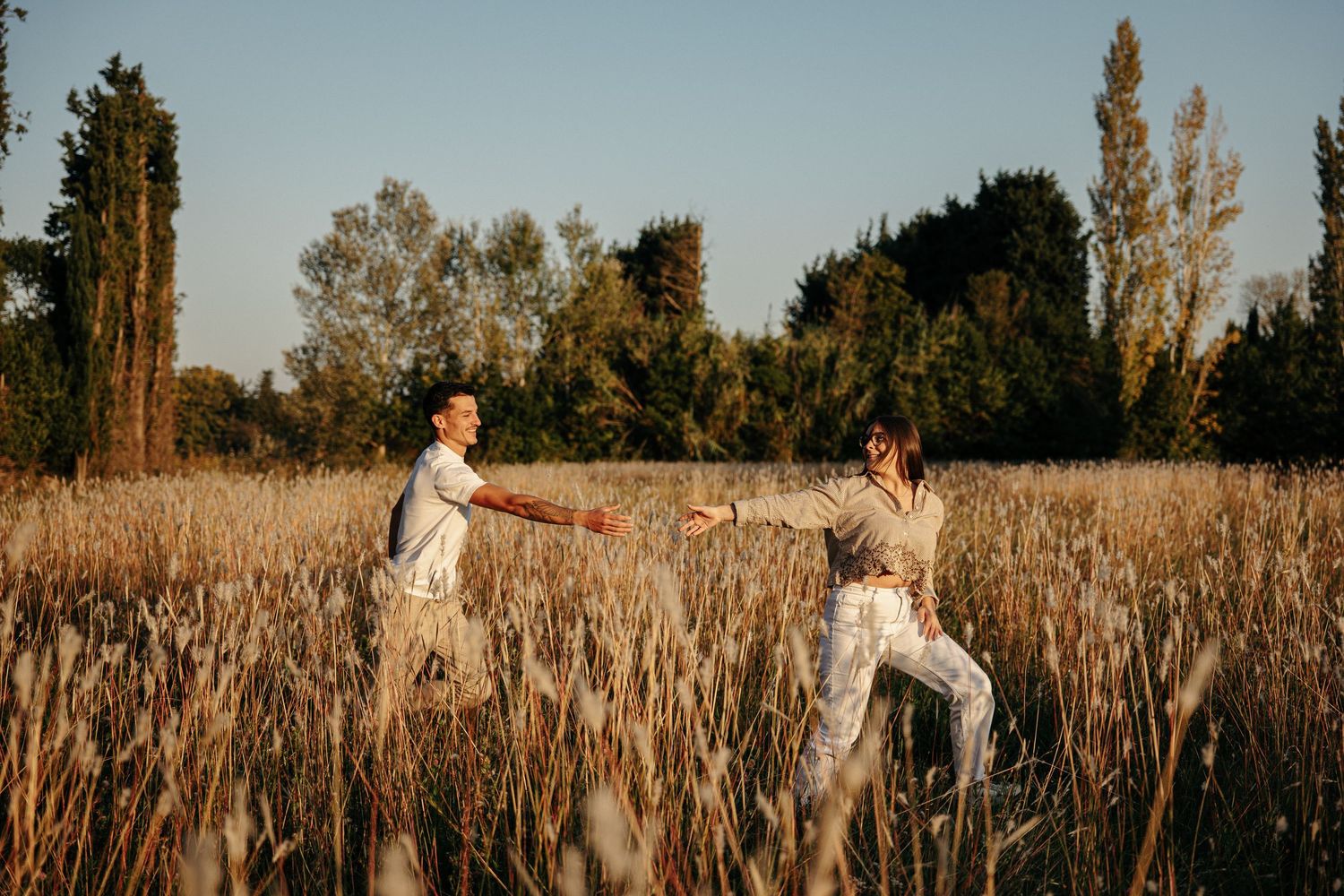Portrait d'un couple au coucher du soleil dans une lumière dorée.