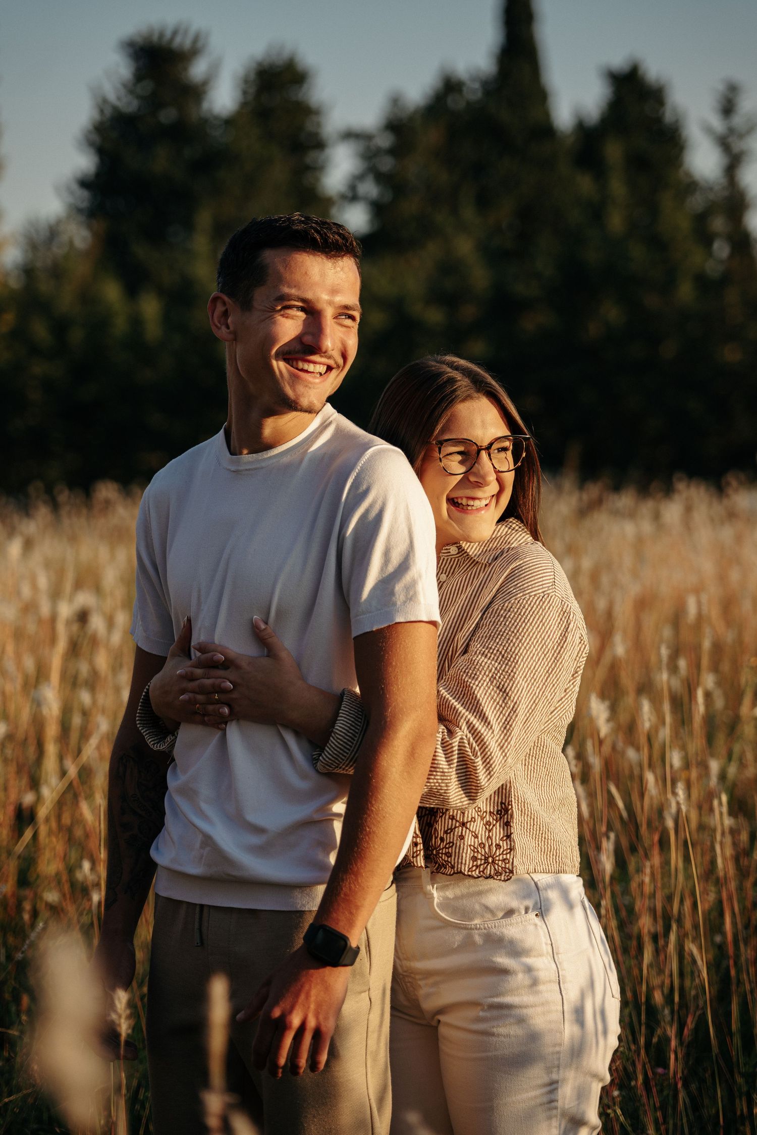 Portrait d'un couple au coucher du soleil dans une lumière dorée.