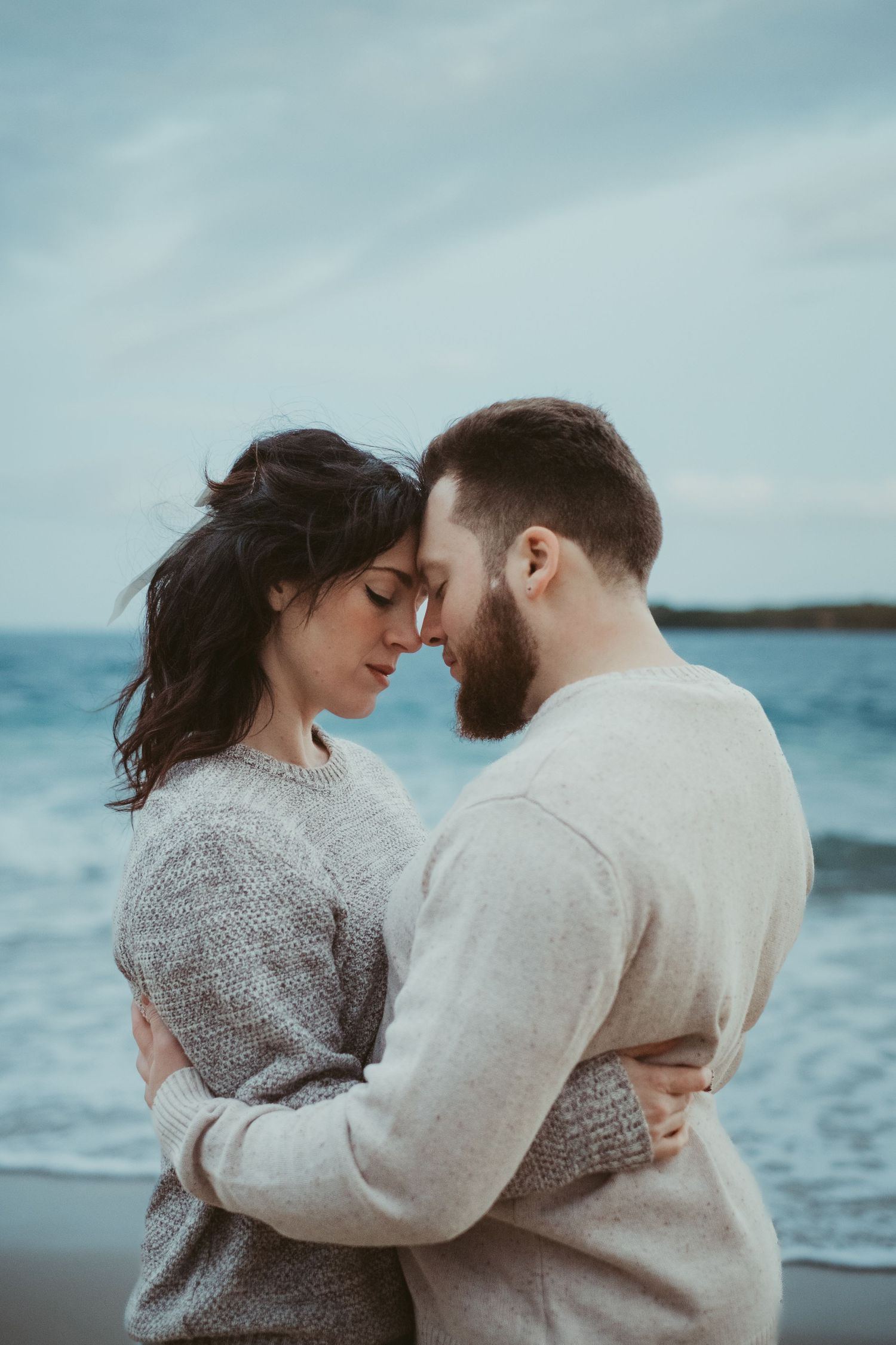 Couple embracing at beach at twilight.