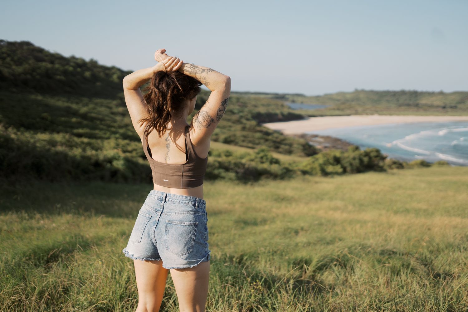 Girl staring out across view of Killalea beach, NSW