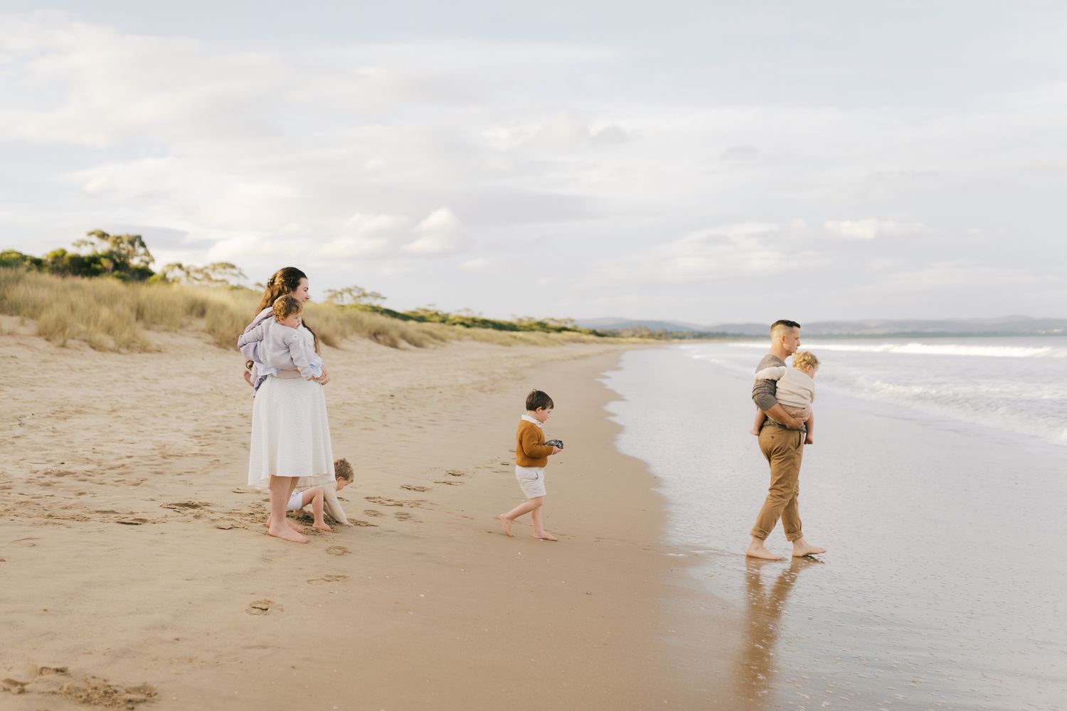 Family of five walking along picturesque beach, Wollongong NSW