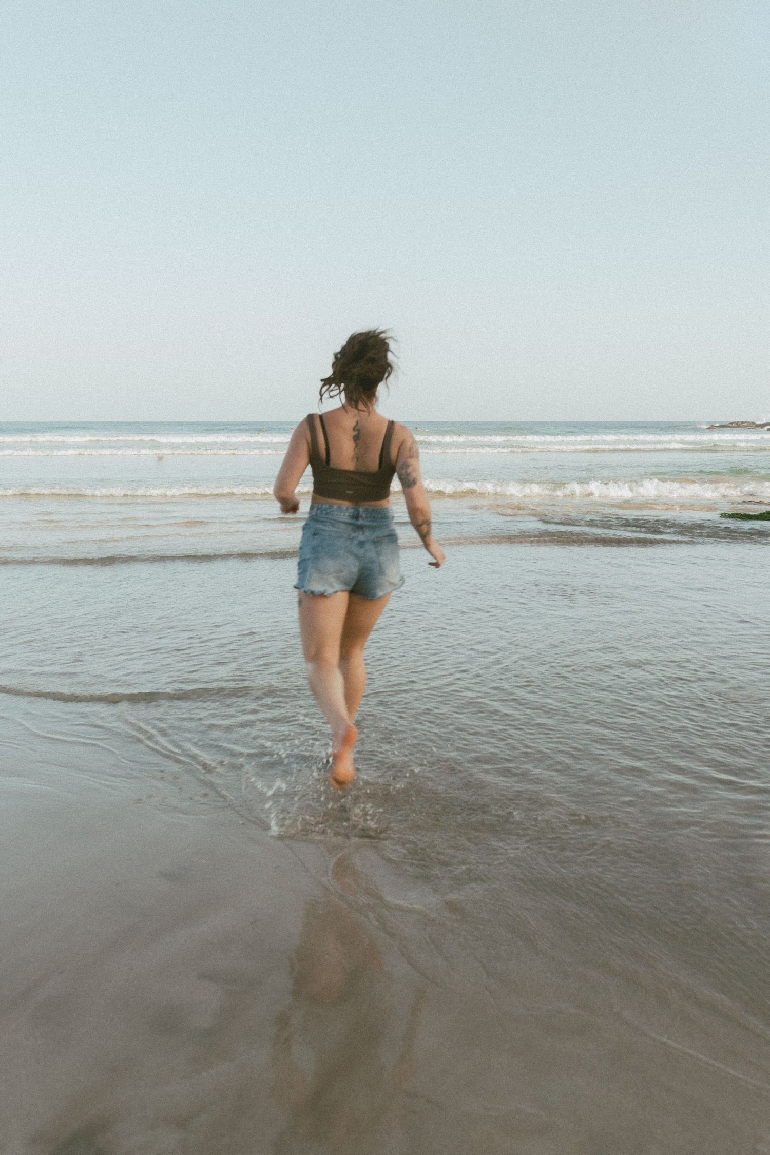 Girl running into waves at Killalea Beach, NSW