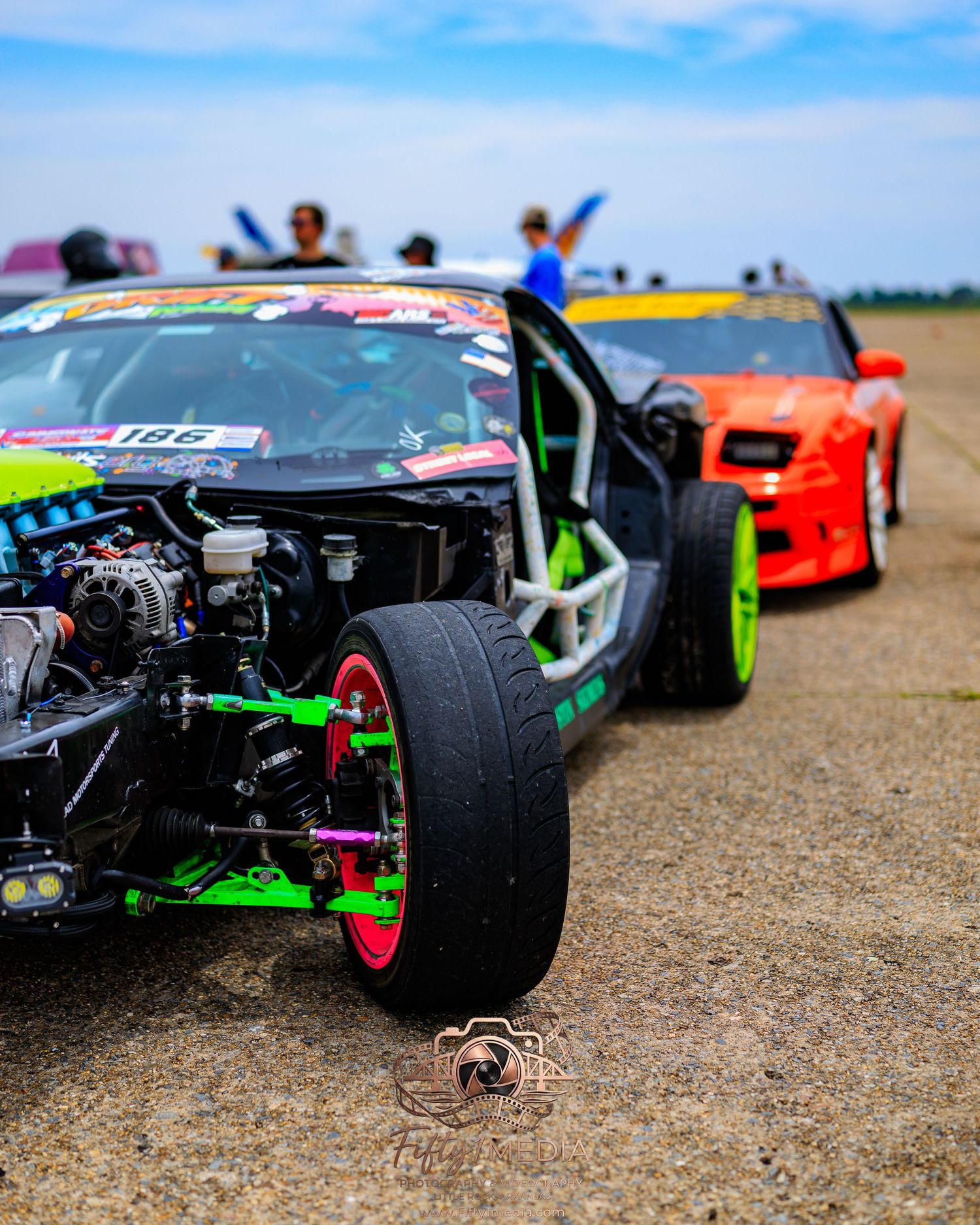 Green and black drift car with its hood removed exposing the engine at an Arkansas car show.