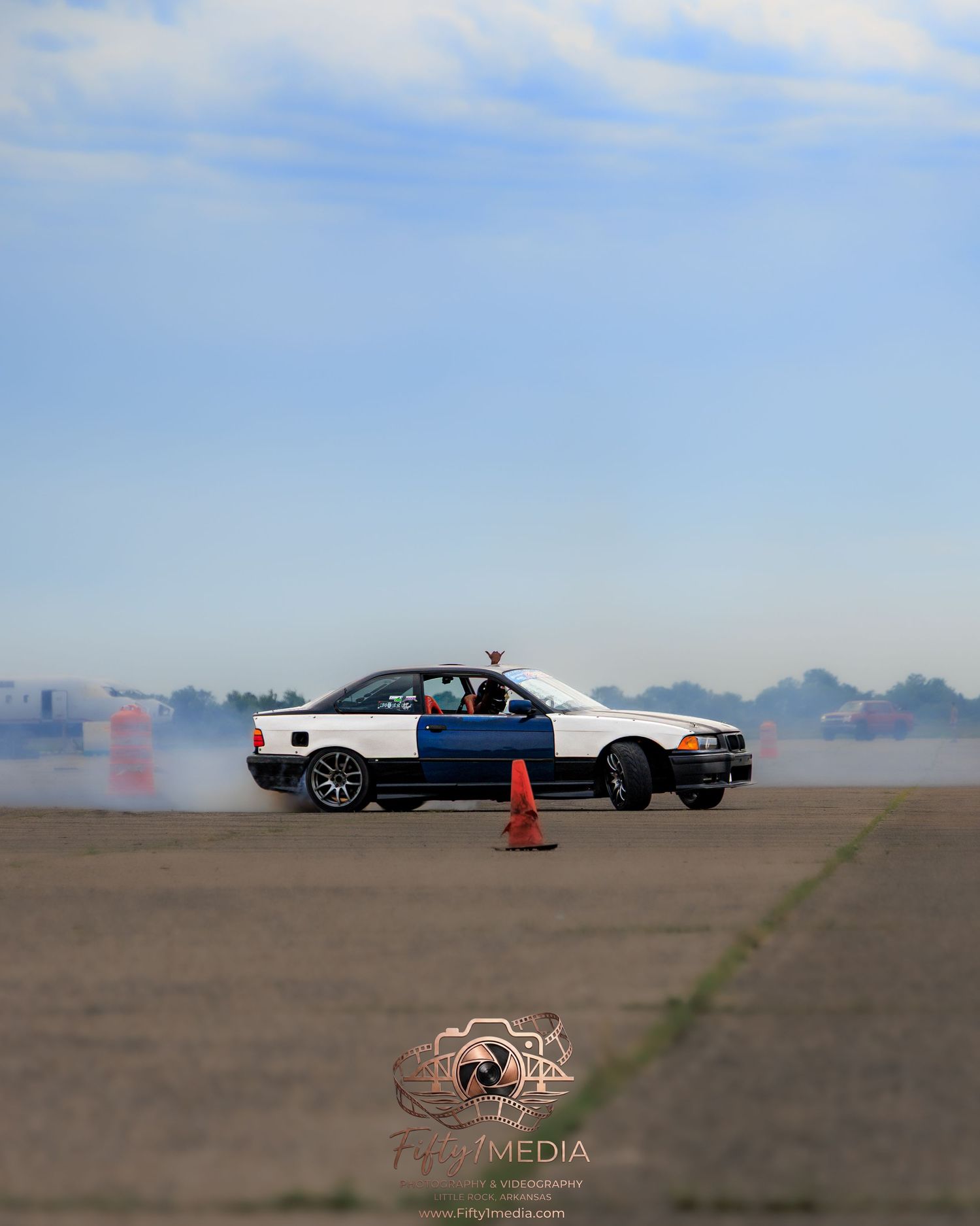 Police-themed white and black drift car sliding on a runway track, Arkansas automotive videography.