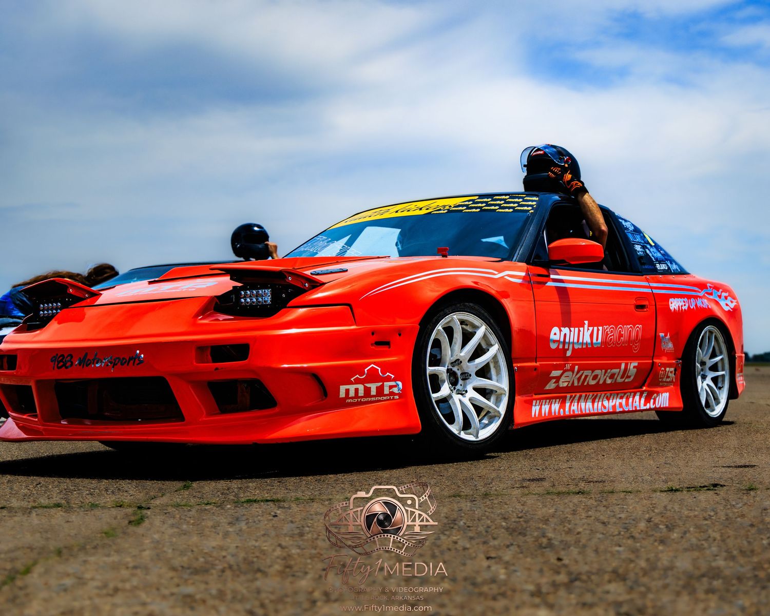 Red drift car parked on an airport runway, automotive photography by Fifty1Media.