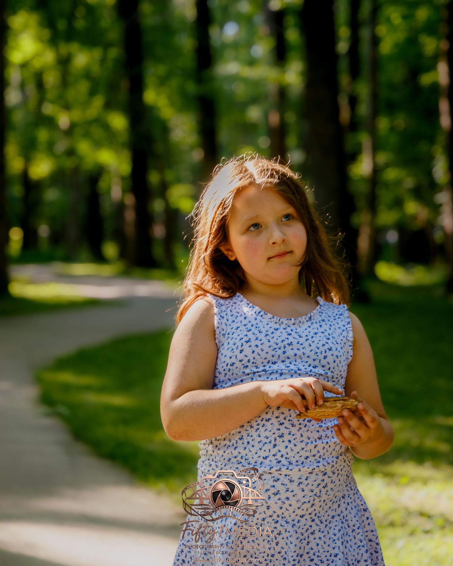 Child standing on a walking path in a lush green park, Little Rock outdoor family photographer.